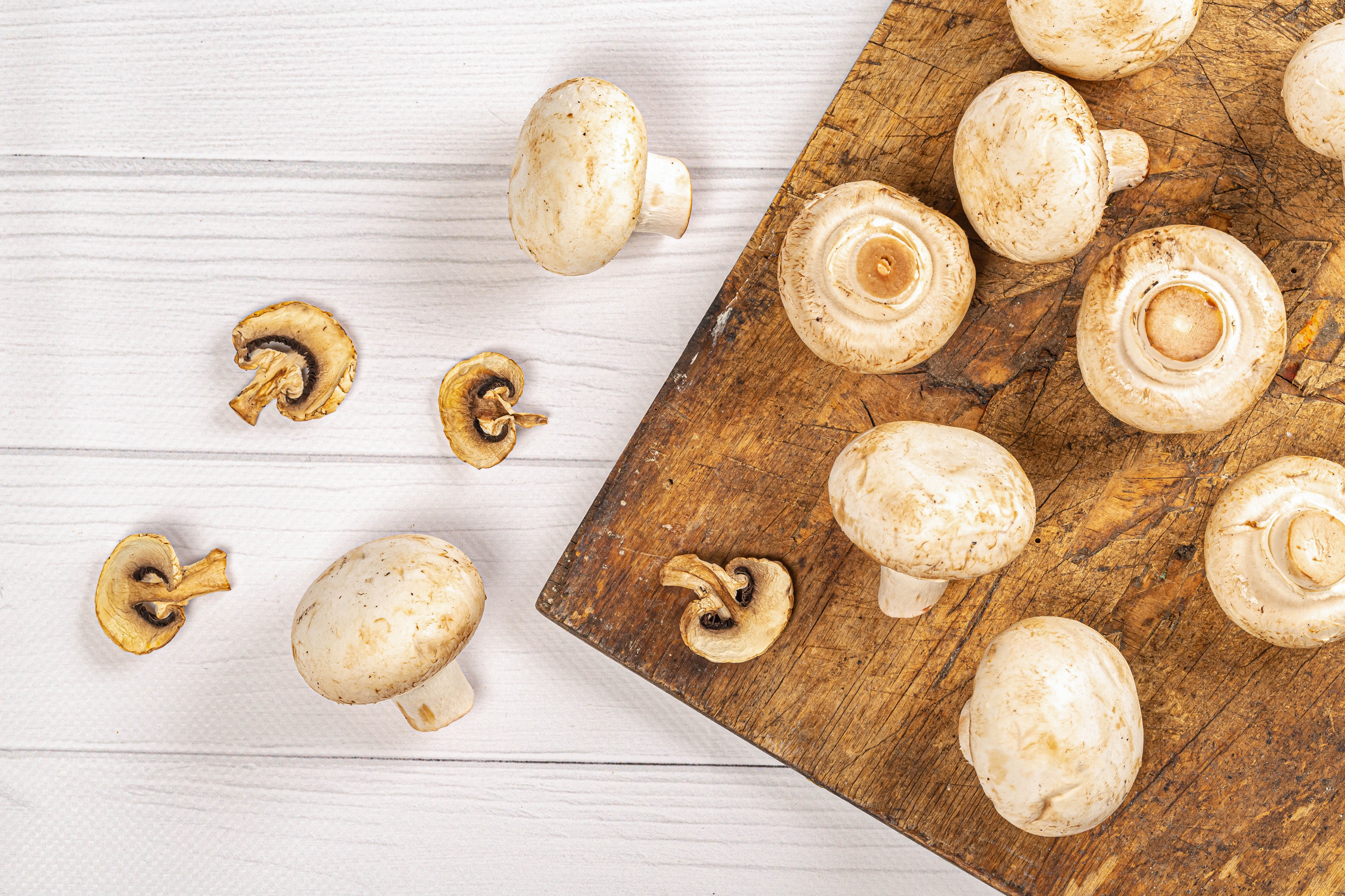 Mushrooms on a wooden cutting board and white planks HD Wallpaper