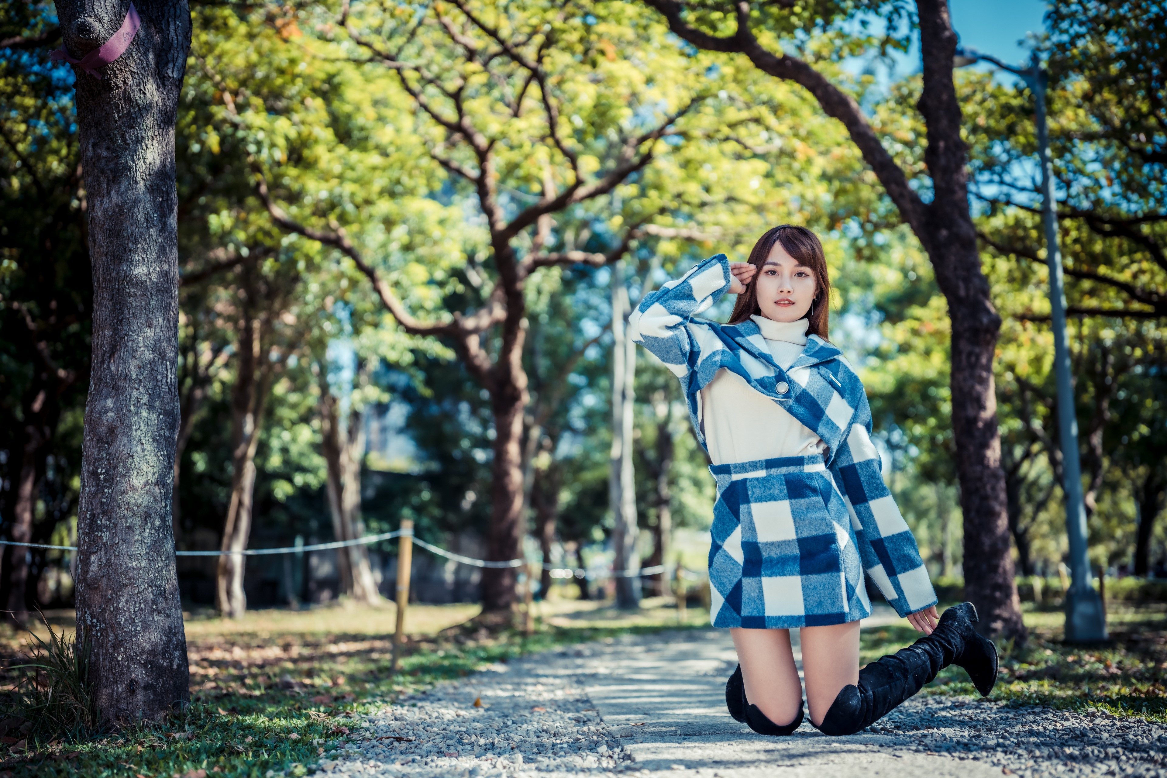 Asian woman in plaid outfit in park HD Wallpaper