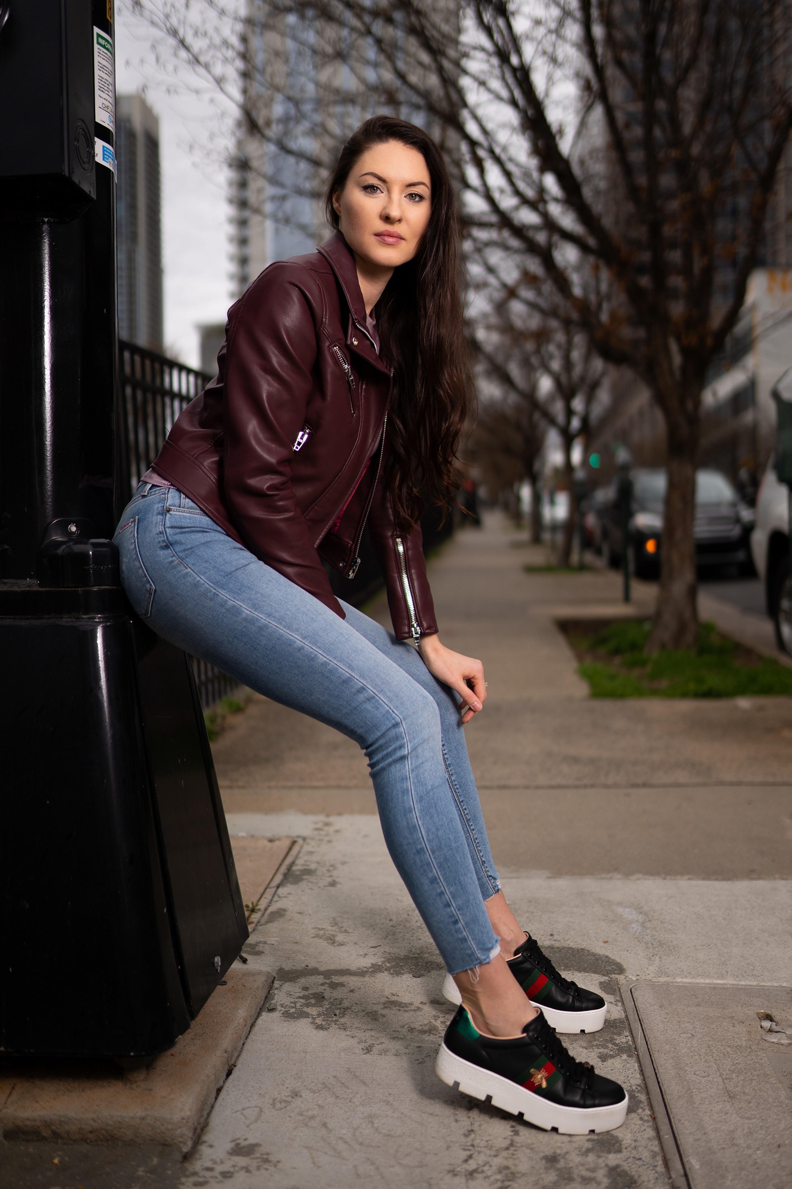 Woman in leather jacket and jeans posing outdoors HD Phone Wallpaper