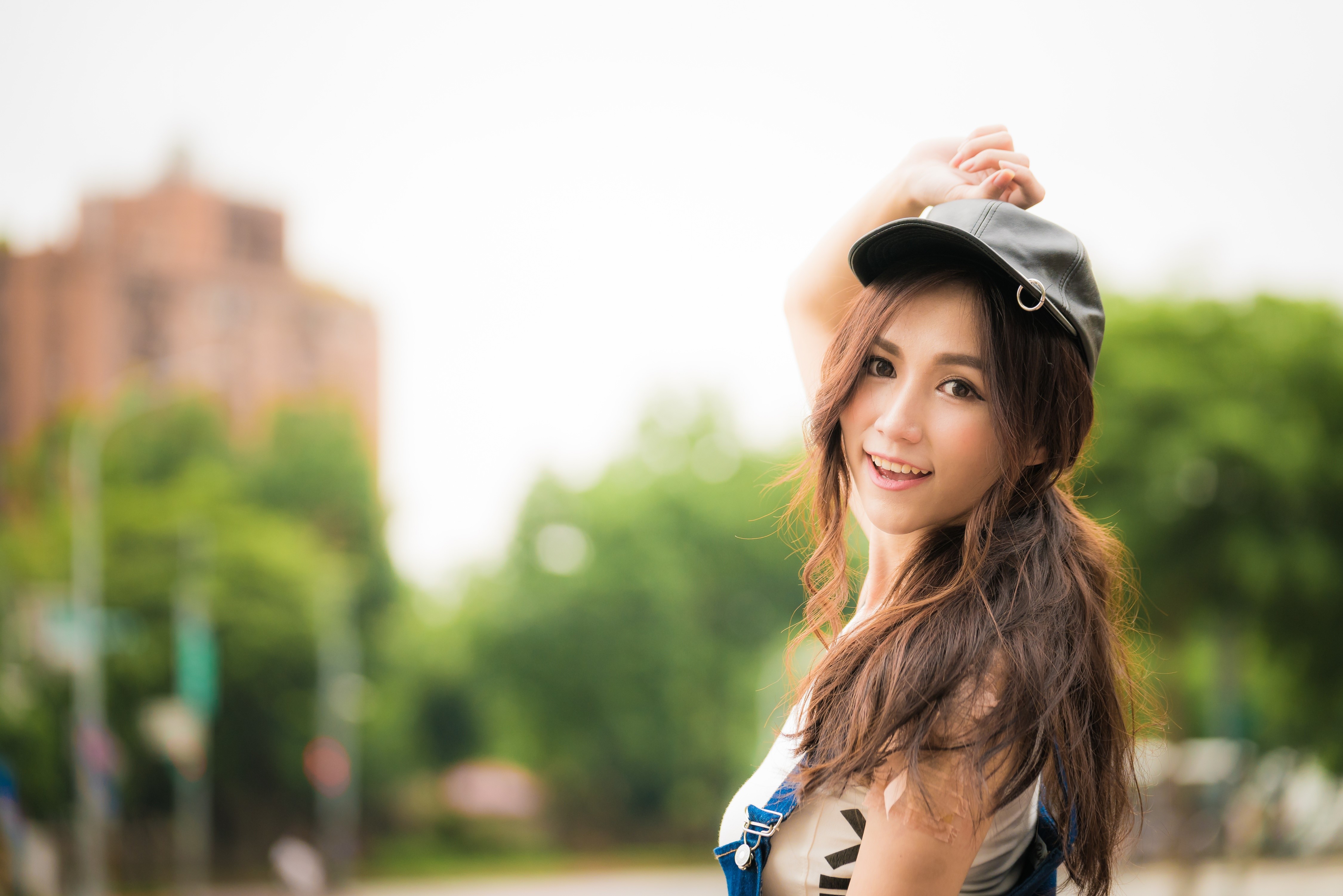 Asian woman with baseball cap smiling HD Wallpaper