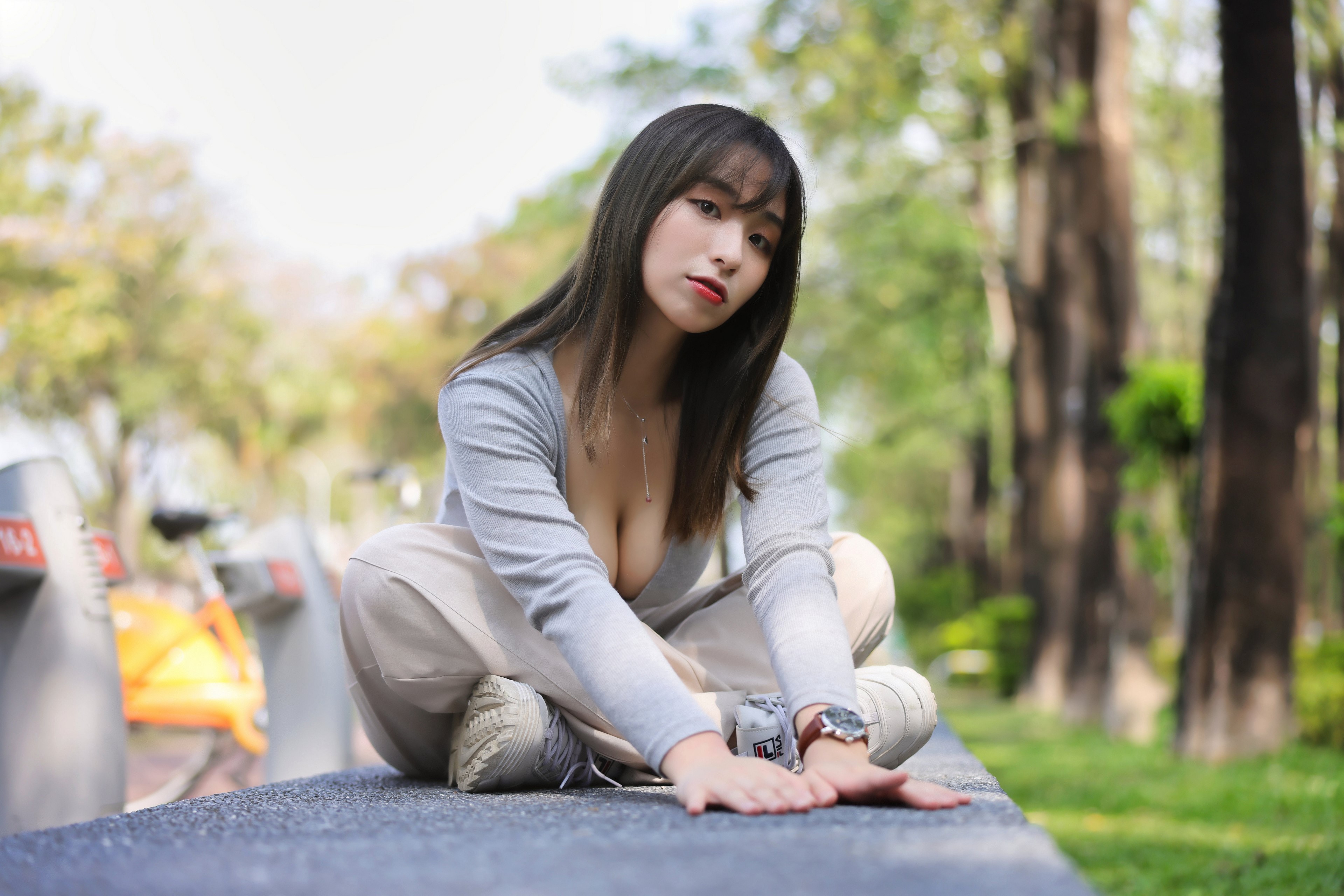 Asian woman sitting in a park HD Wallpaper