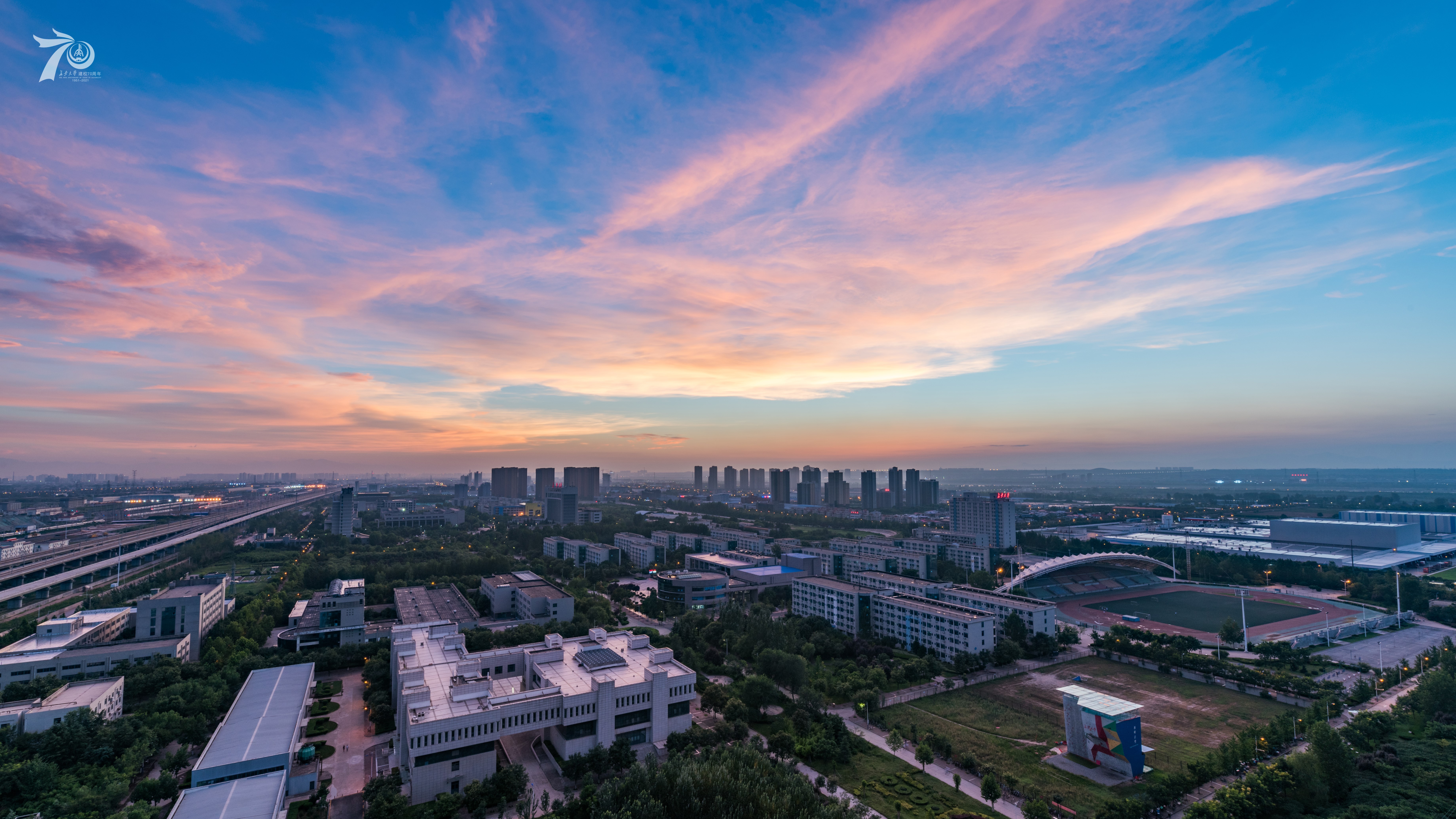 Cityscape at sunset with university campus and stadium HD Wallpaper