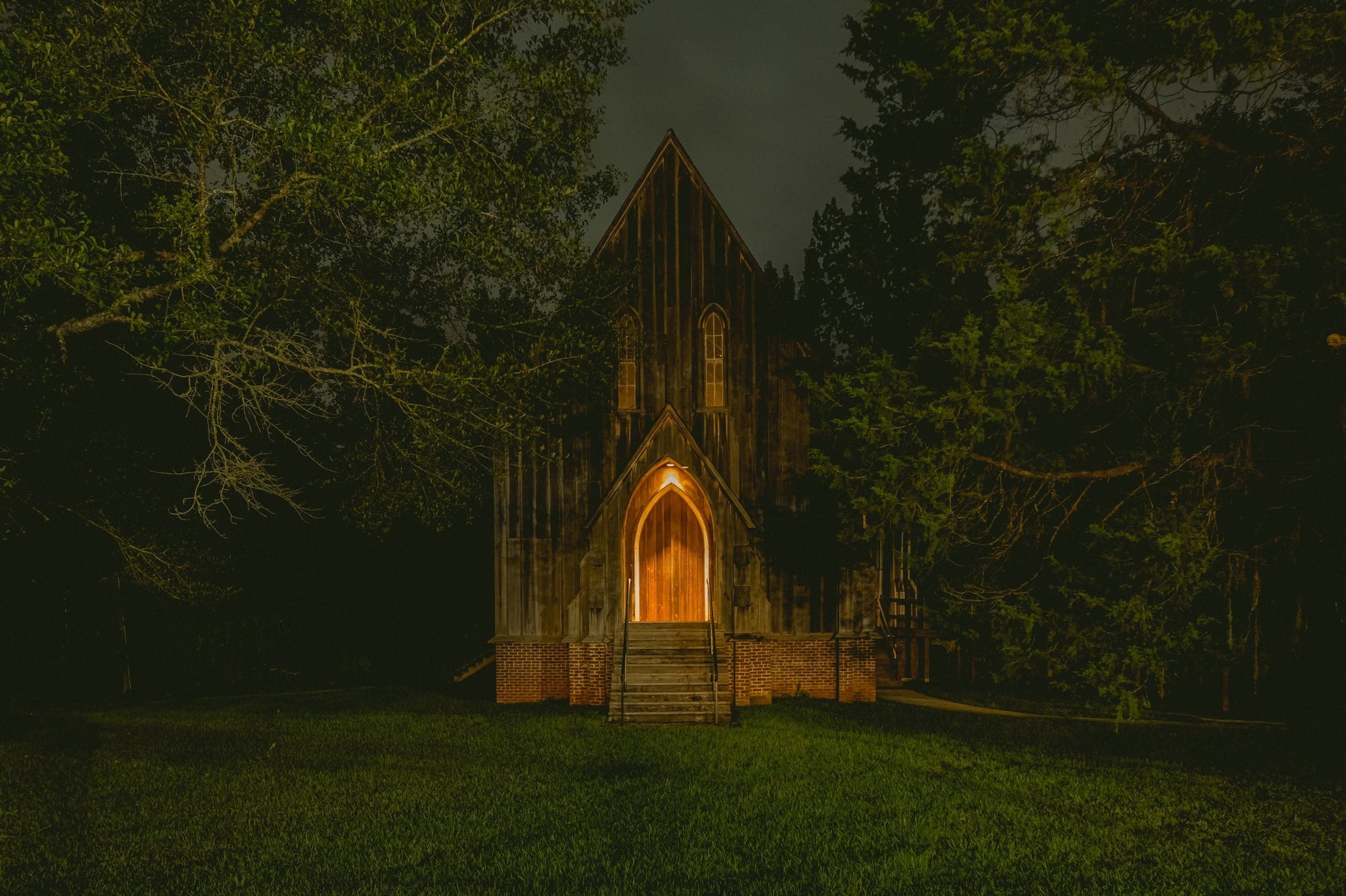 Old wooden church at night surrounded by trees HD Wallpaper