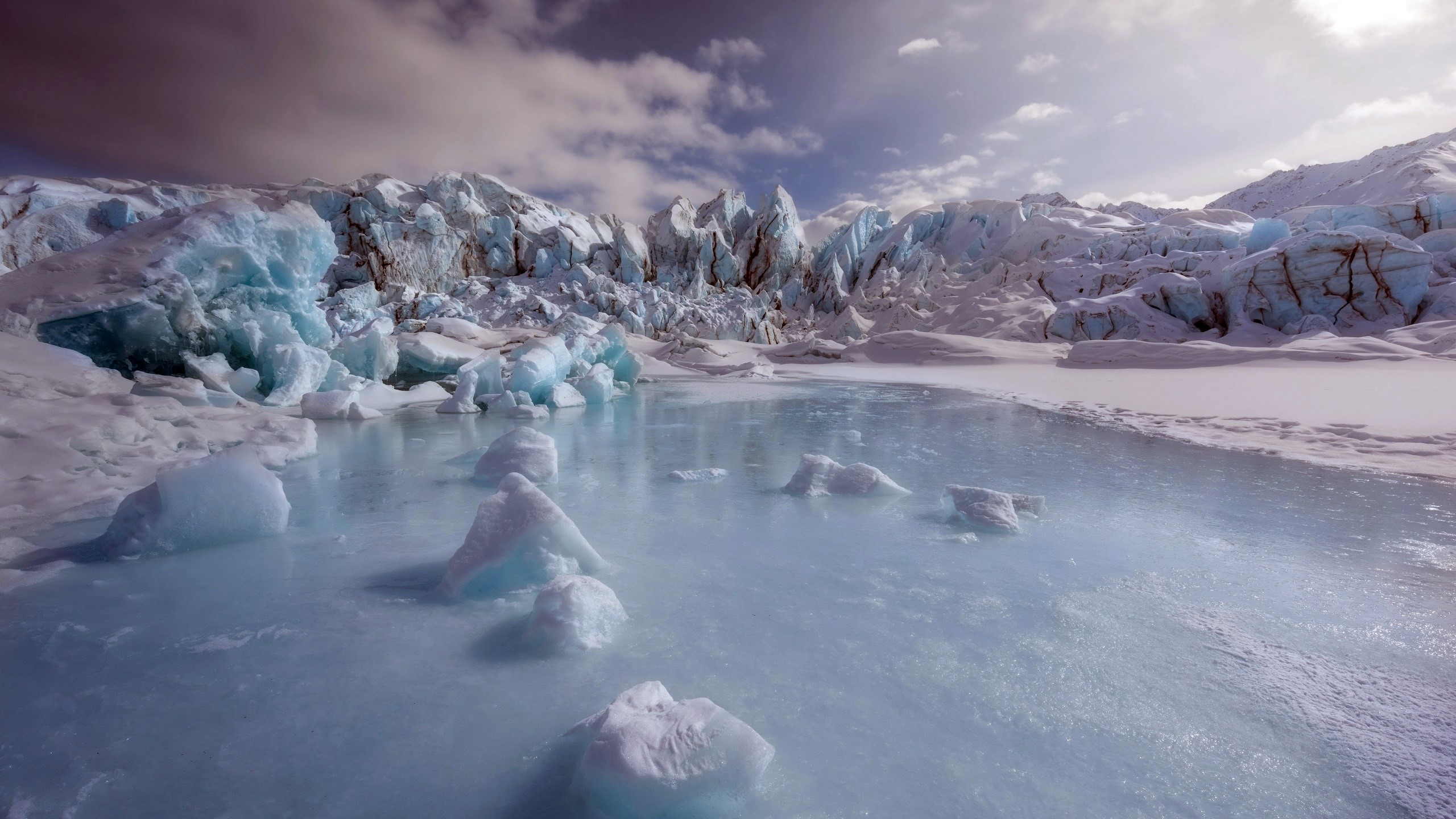 Glacier and icy lake under a cloudy sky HD Wallpaper