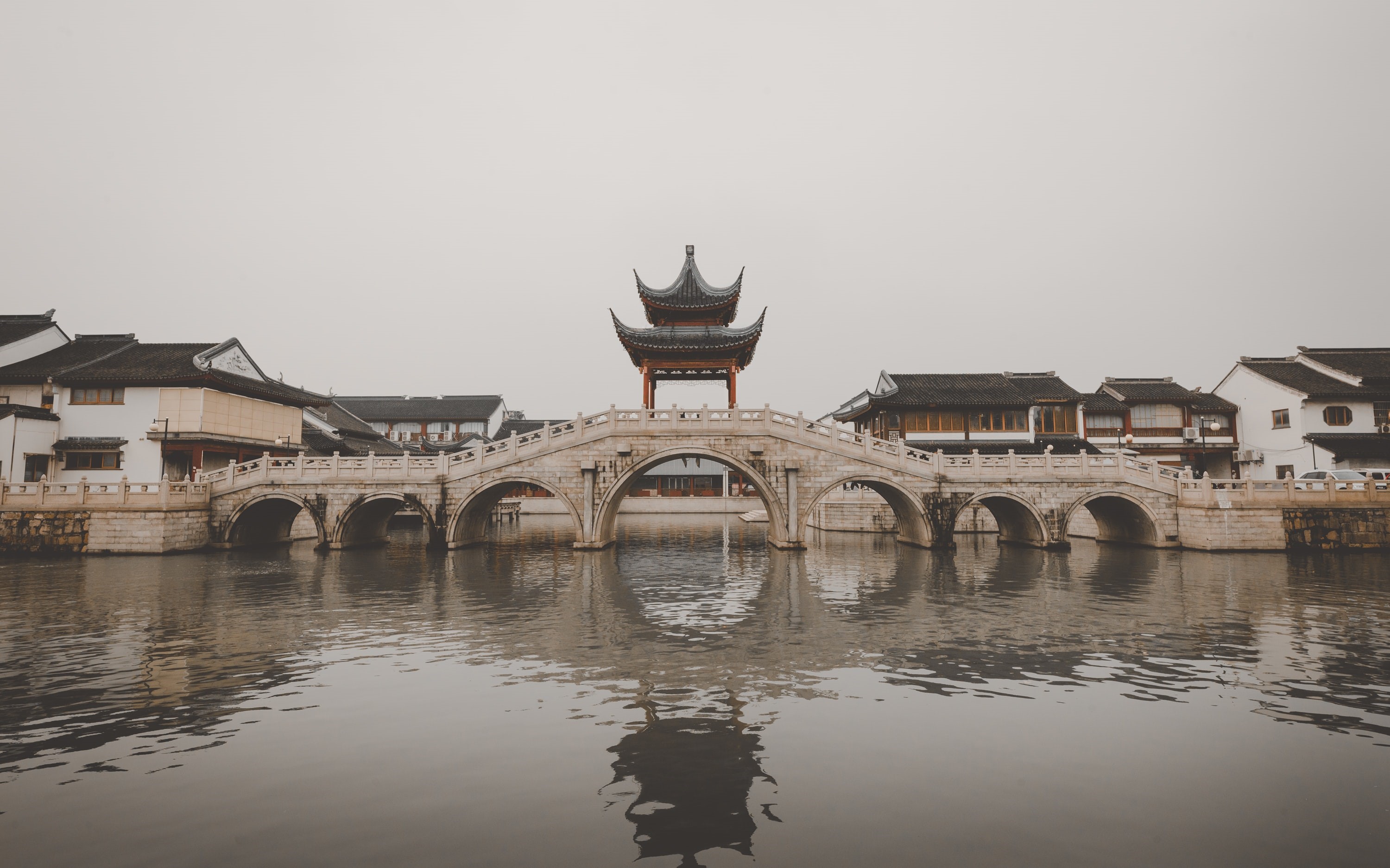 Stone bridge with Chinese architecture over water HD Wallpaper