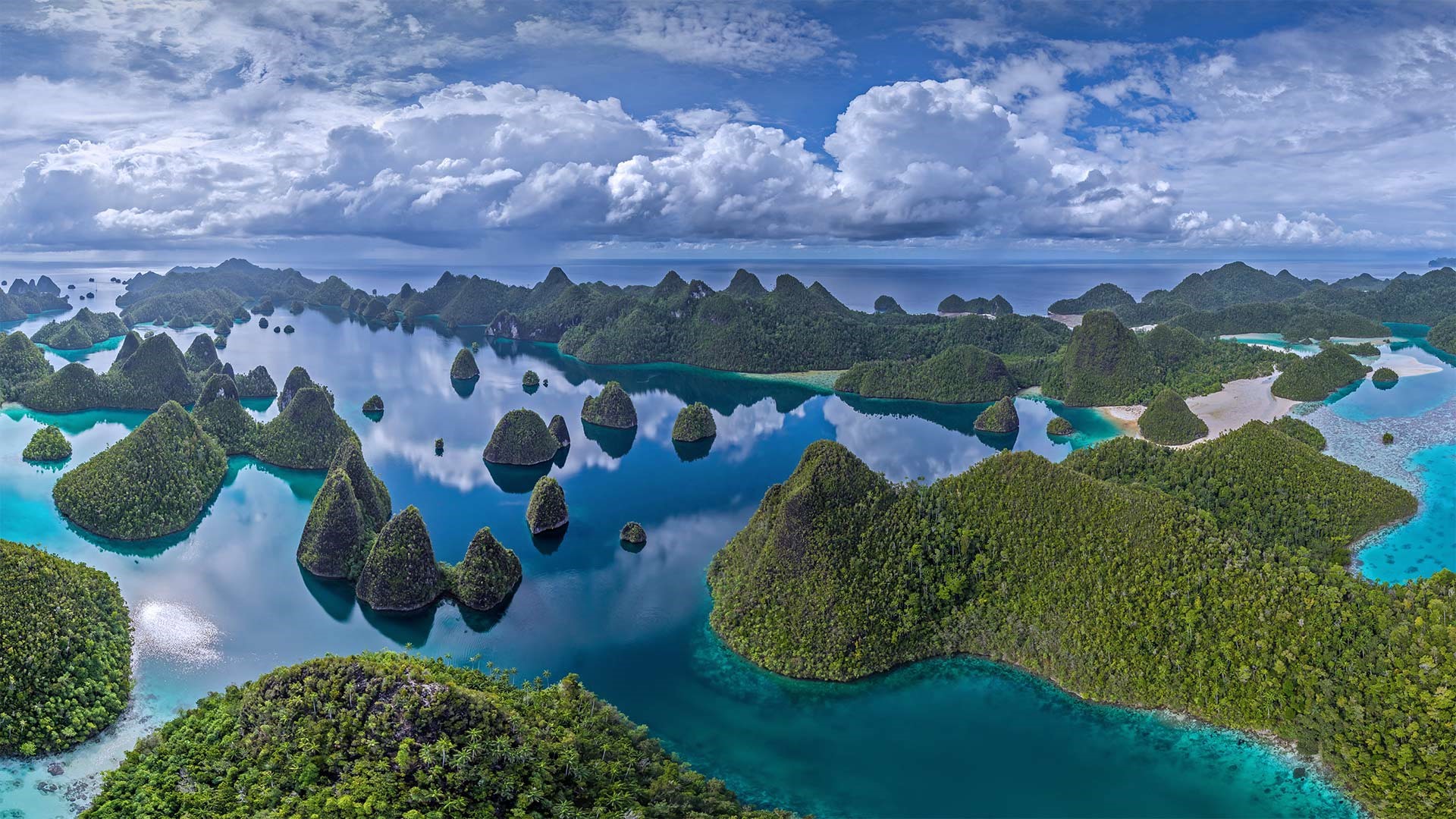 Aerial view of tropical islands with lush green trees and blue water HD Wallpaper