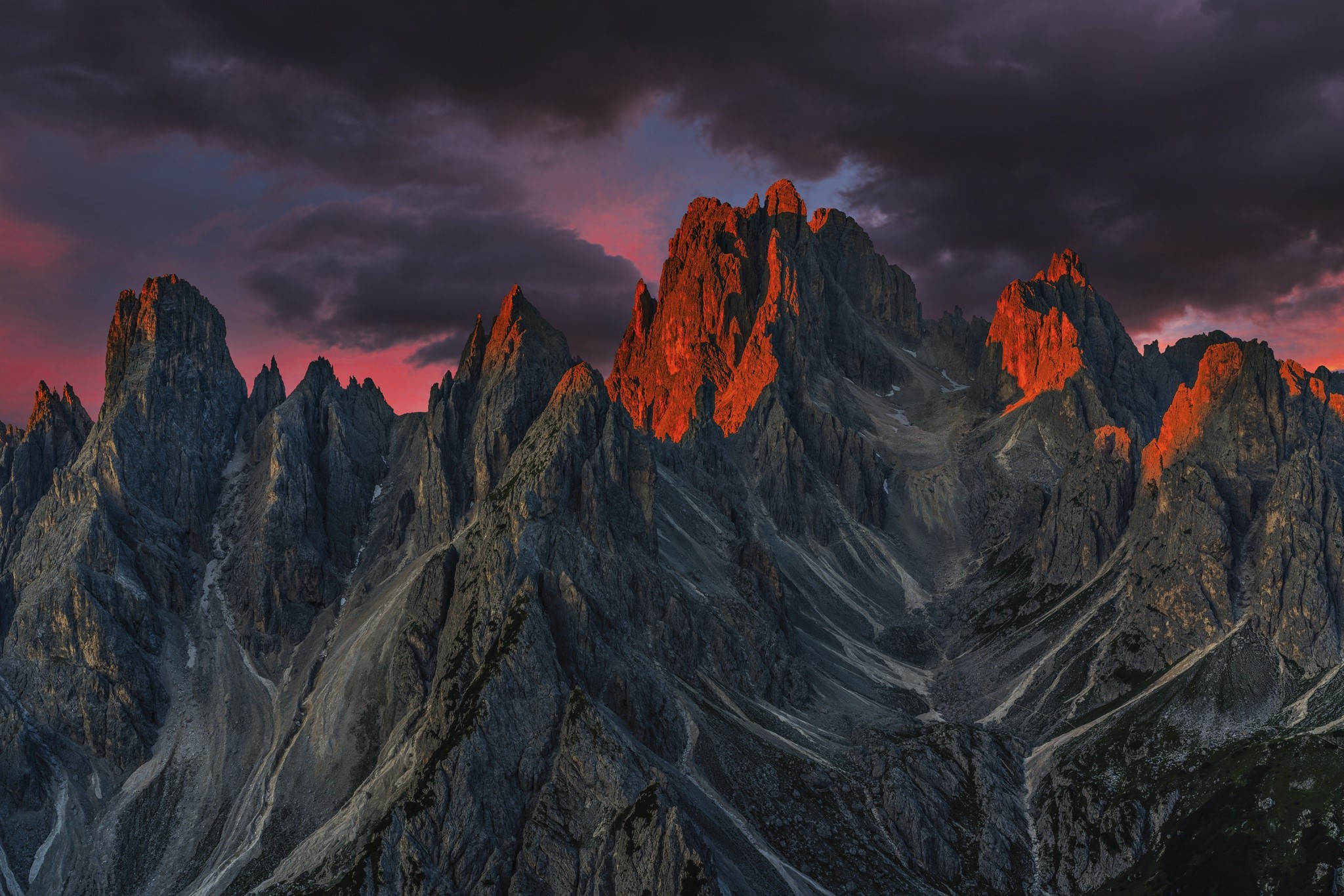 Jagged mountain peaks at sunset with dramatic clouds HD Wallpaper