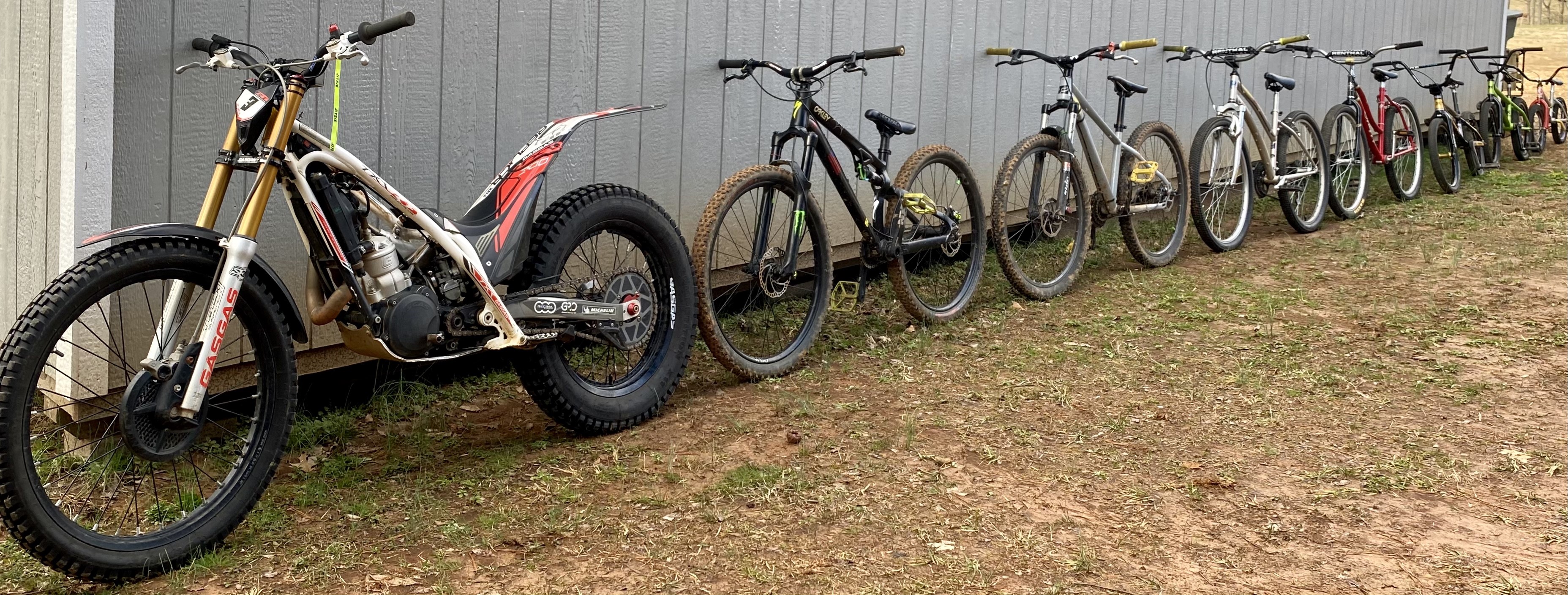 Trial motorcycle and bicycles lined up HD Wallpaper