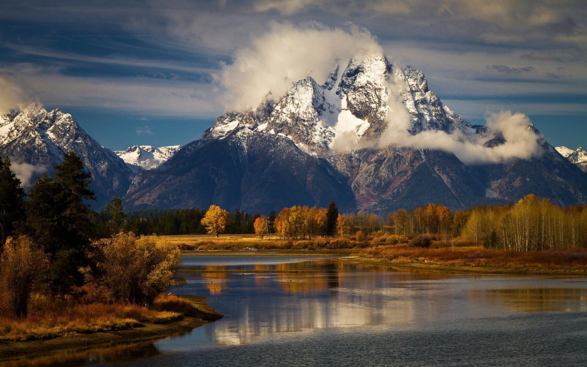 Snowy mountains reflected in a river with autumn trees HD Wallpaper