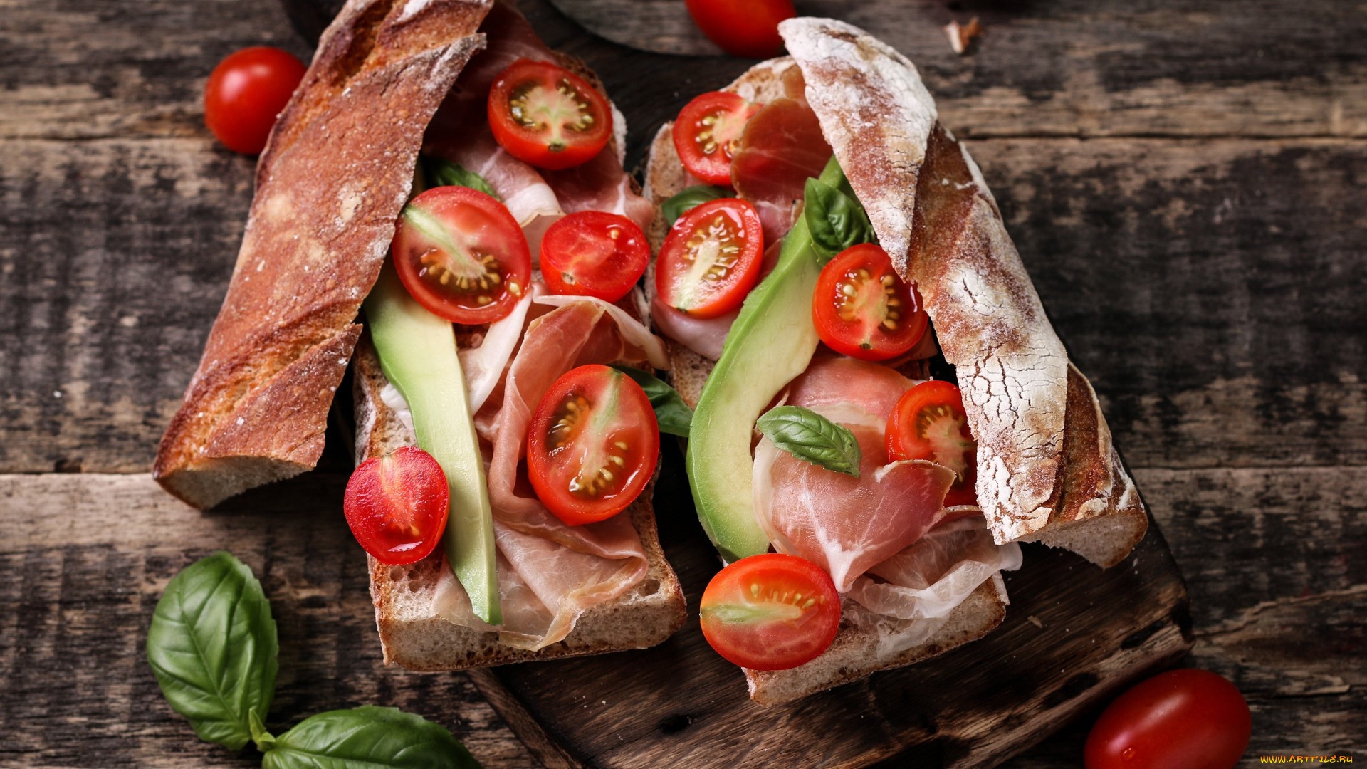 Sandwiches with prosciutto, avocado, tomatoes, and basil on wooden surface HD Wallpaper