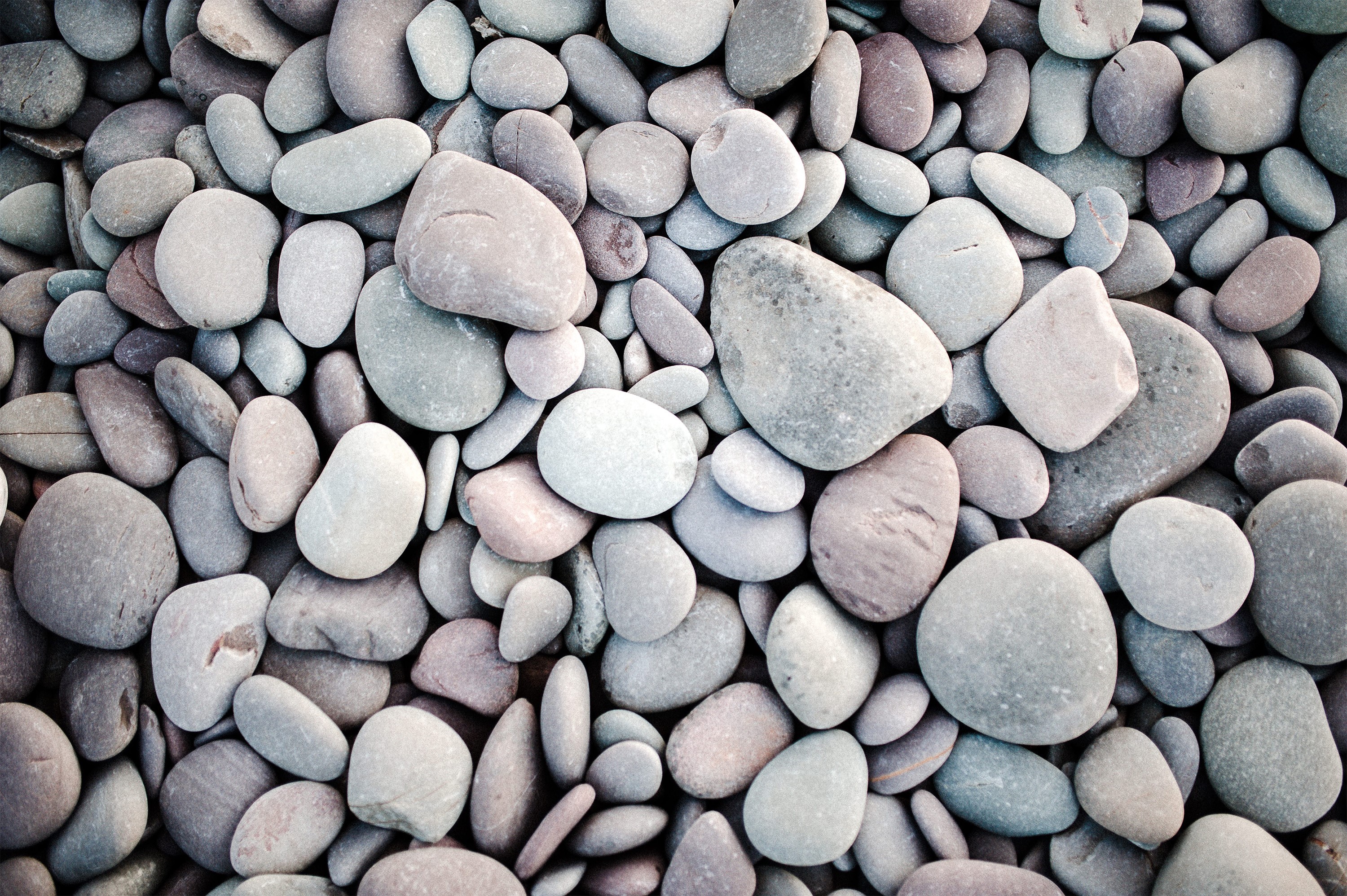 A pile of smooth, rounded stones of various sizes and colors. HD Wallpaper