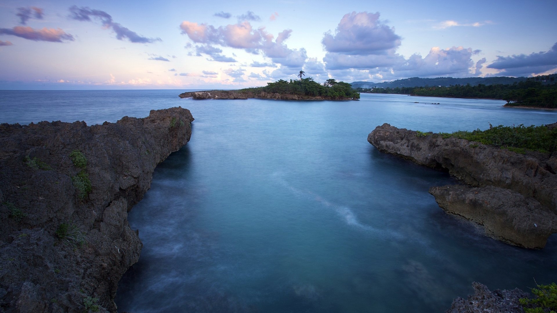 Calm ocean water near rocky shore at dusk HD Wallpaper