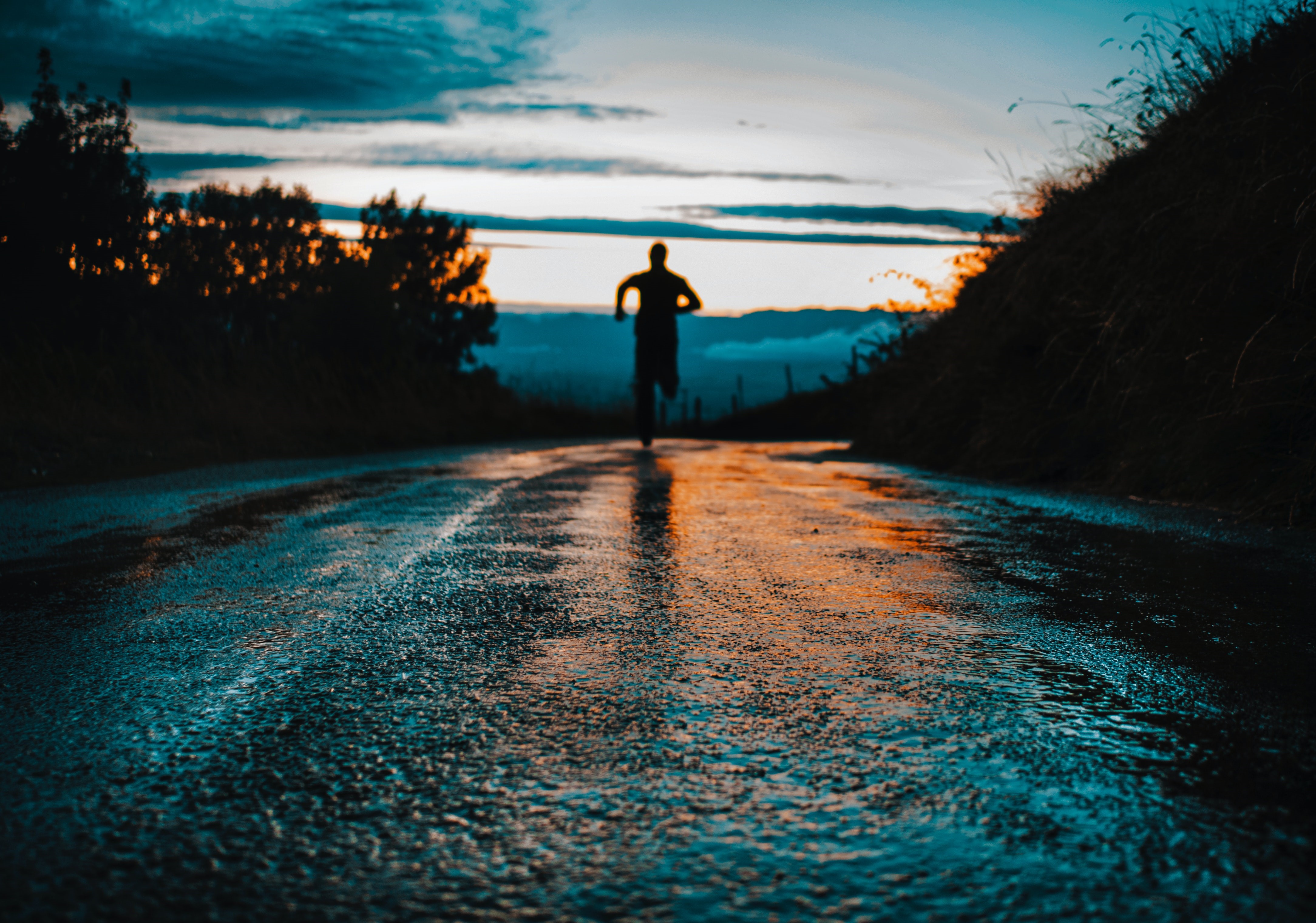Man running on wet road at sunset HD Wallpaper