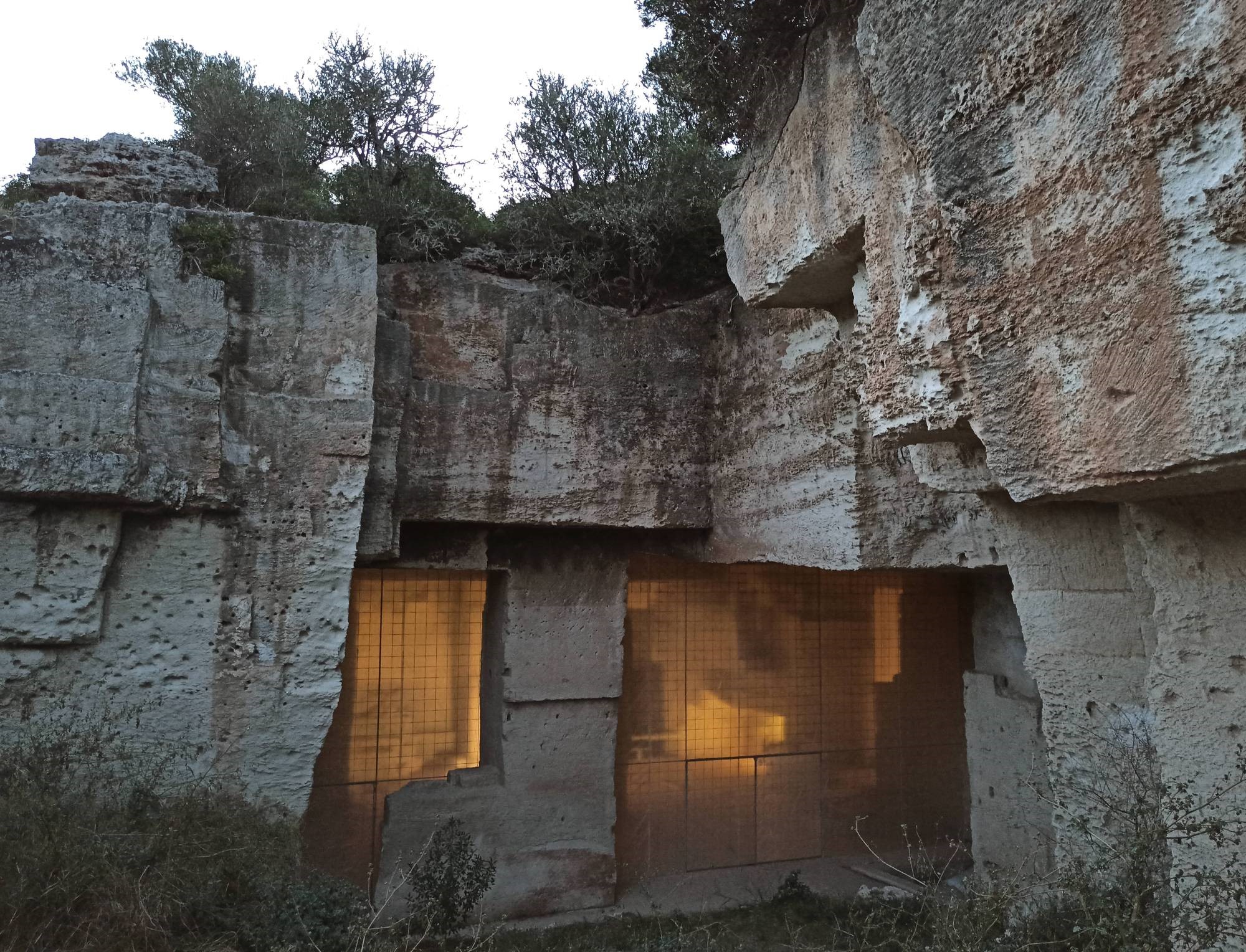 Stone quarry with a fenced opening and trees HD Wallpaper