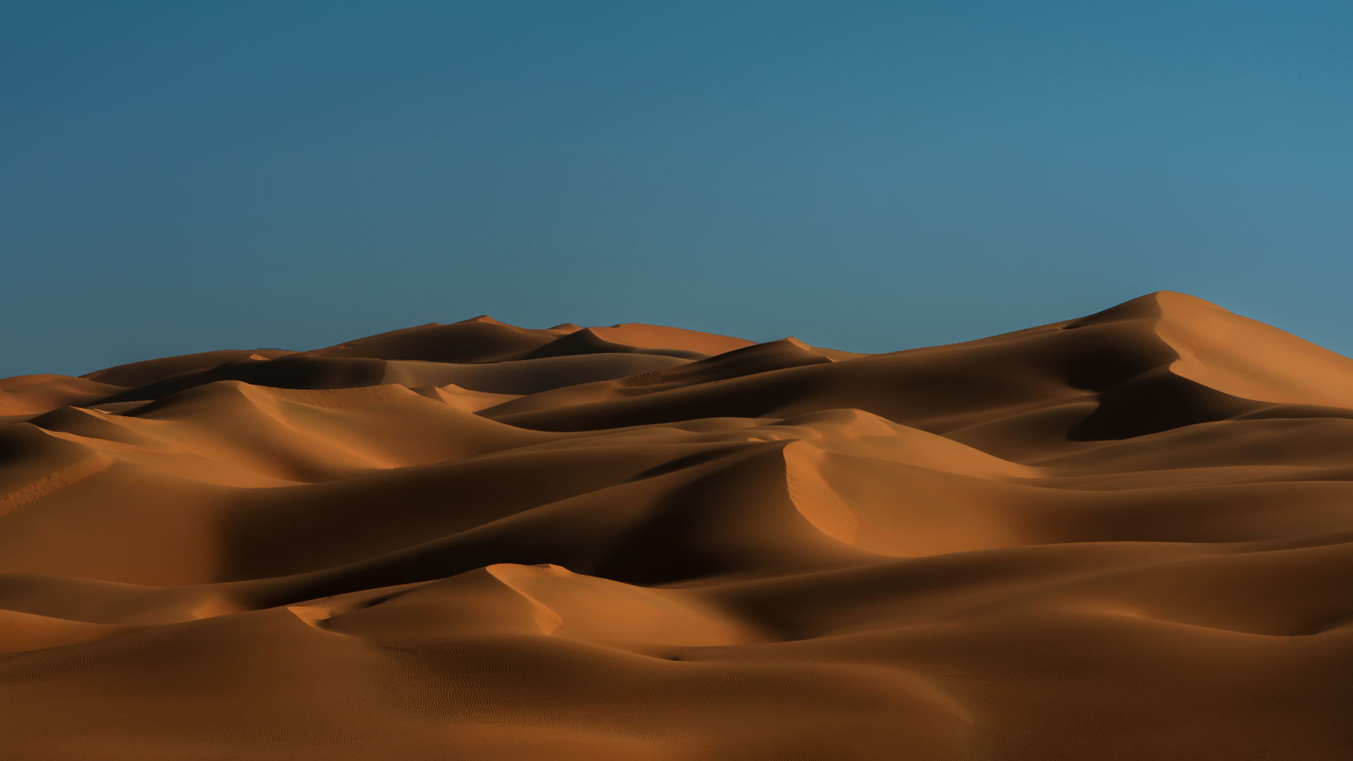 Desert sand dunes under a clear blue sky HD Wallpaper