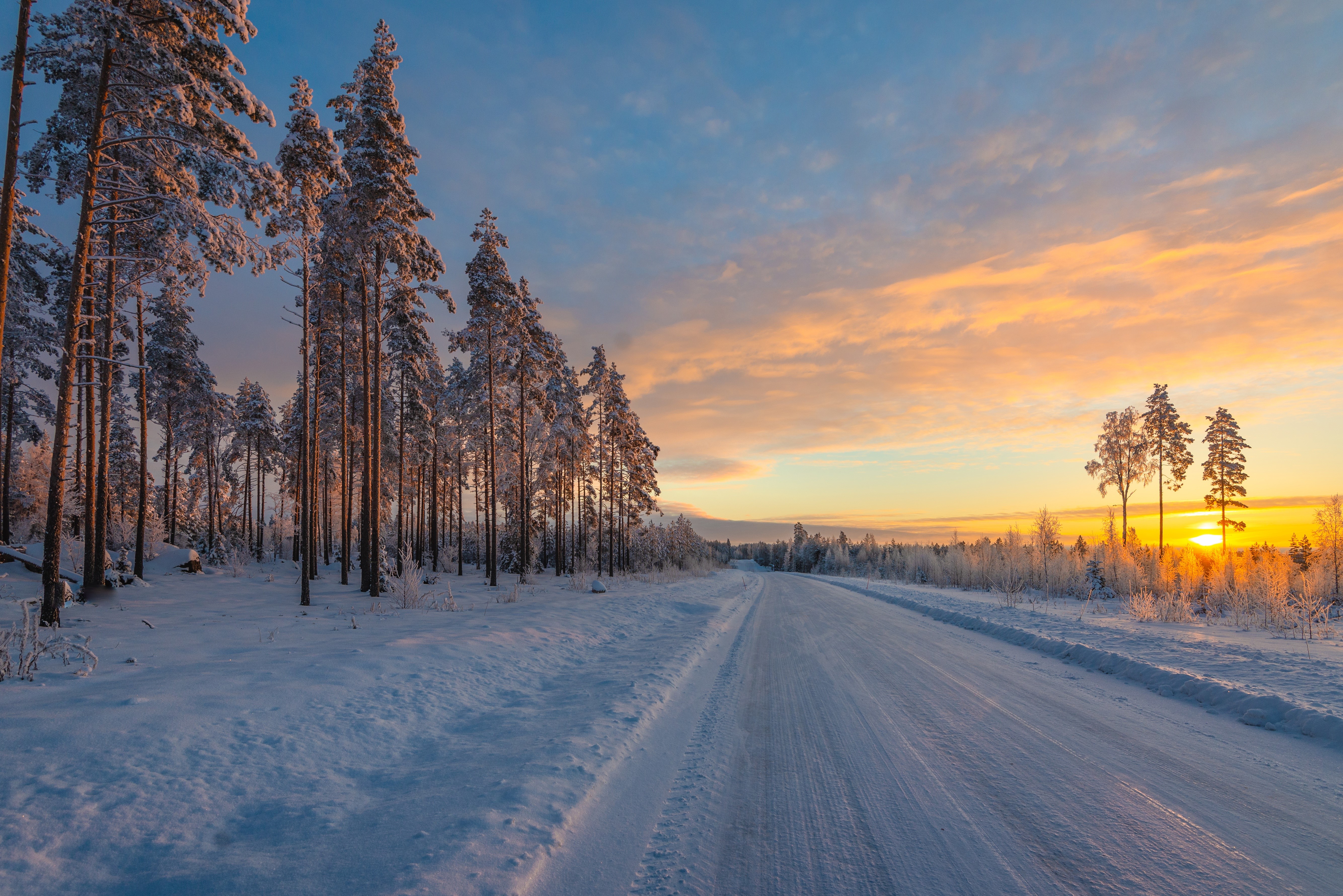 Winter sunset over a snowy road in Finland HD Wallpaper