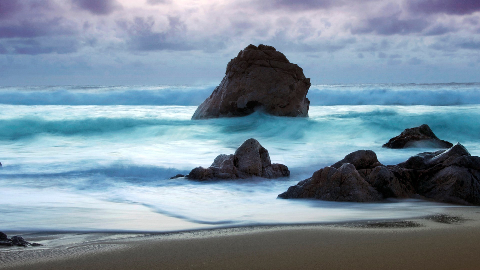Ocean waves crashing on rocks at dusk HD Wallpaper