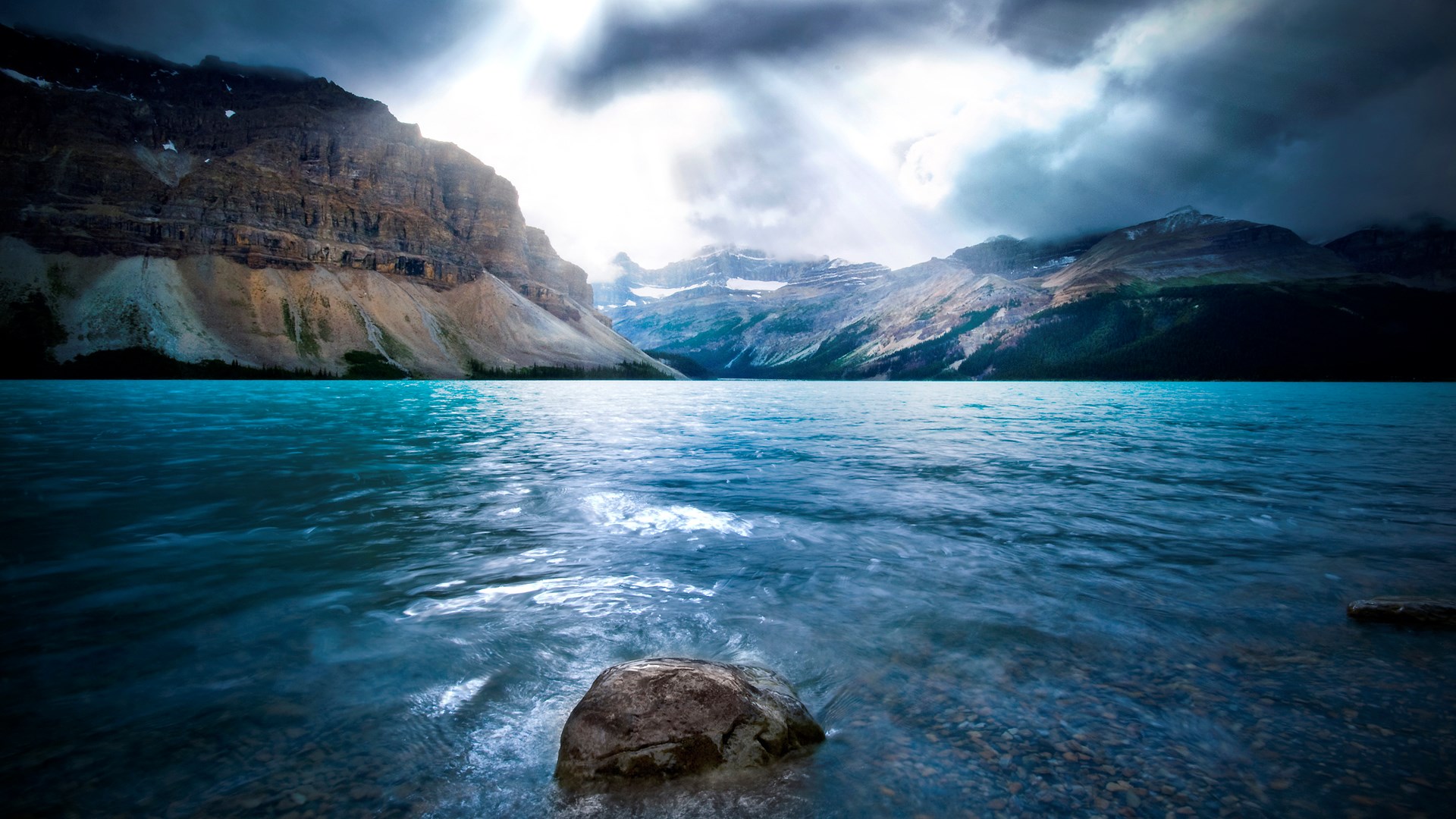 Turquoise lake and rocky mountains under dramatic sky HD Wallpaper