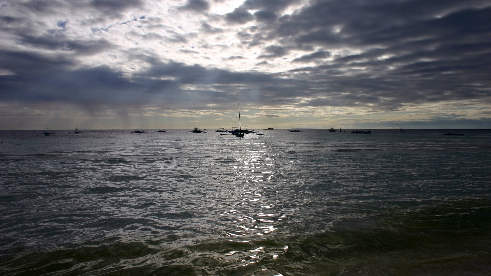 Boats on the ocean under a cloudy sky HD Wallpaper