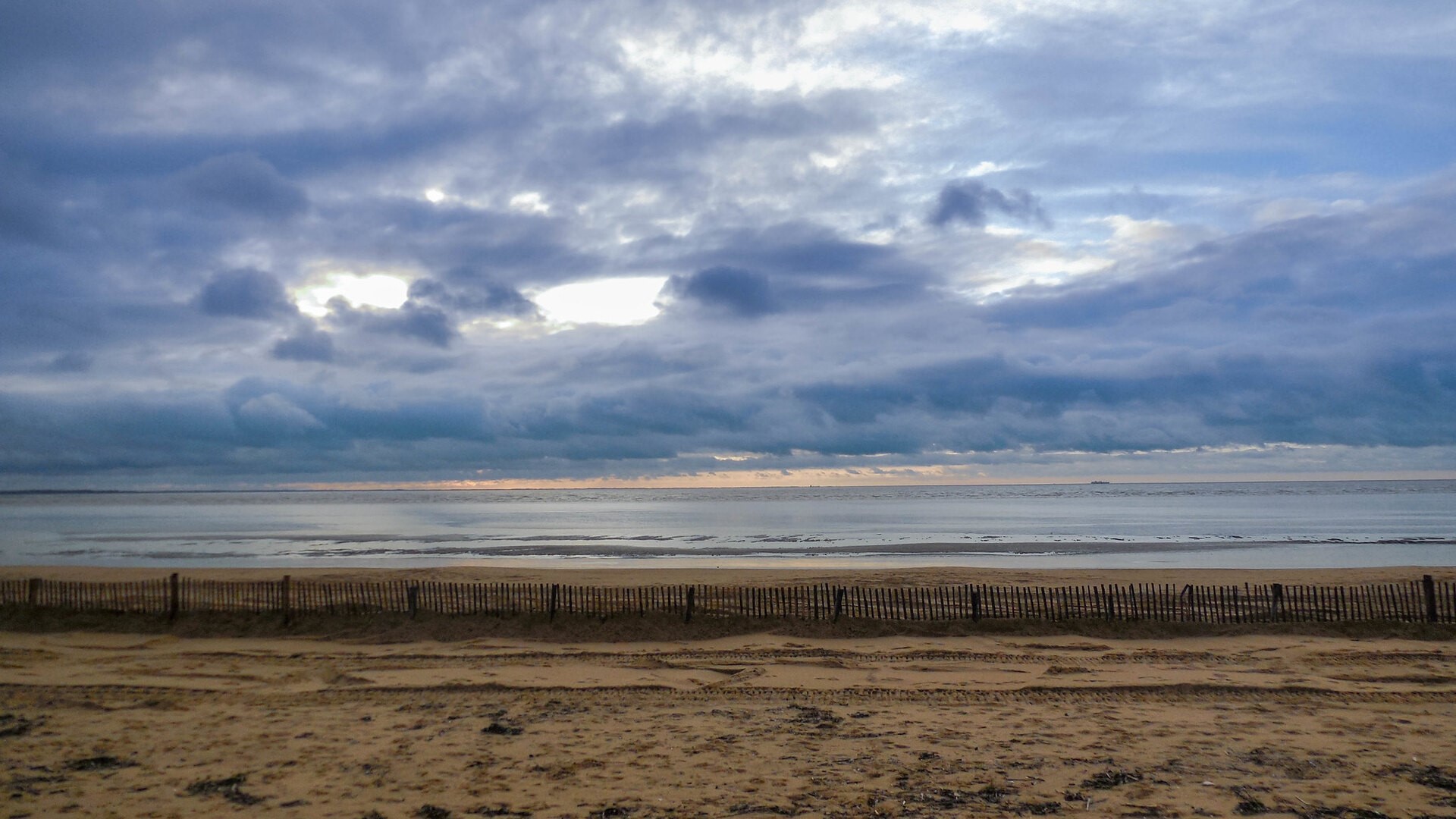 Beach with wooden fence and cloudy sky HD Wallpaper