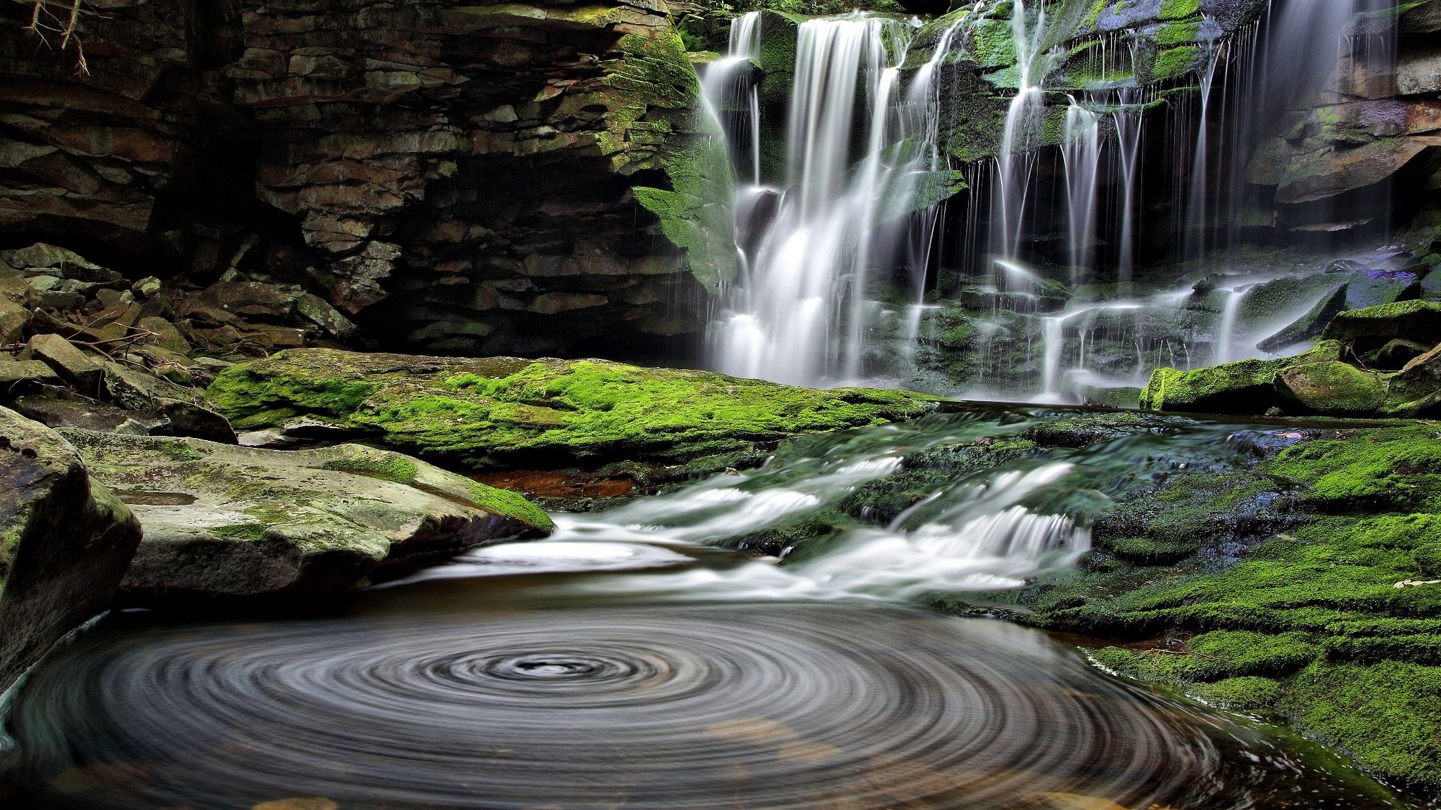 Waterfall cascading over mossy rocks into a swirling pool HD Wallpaper