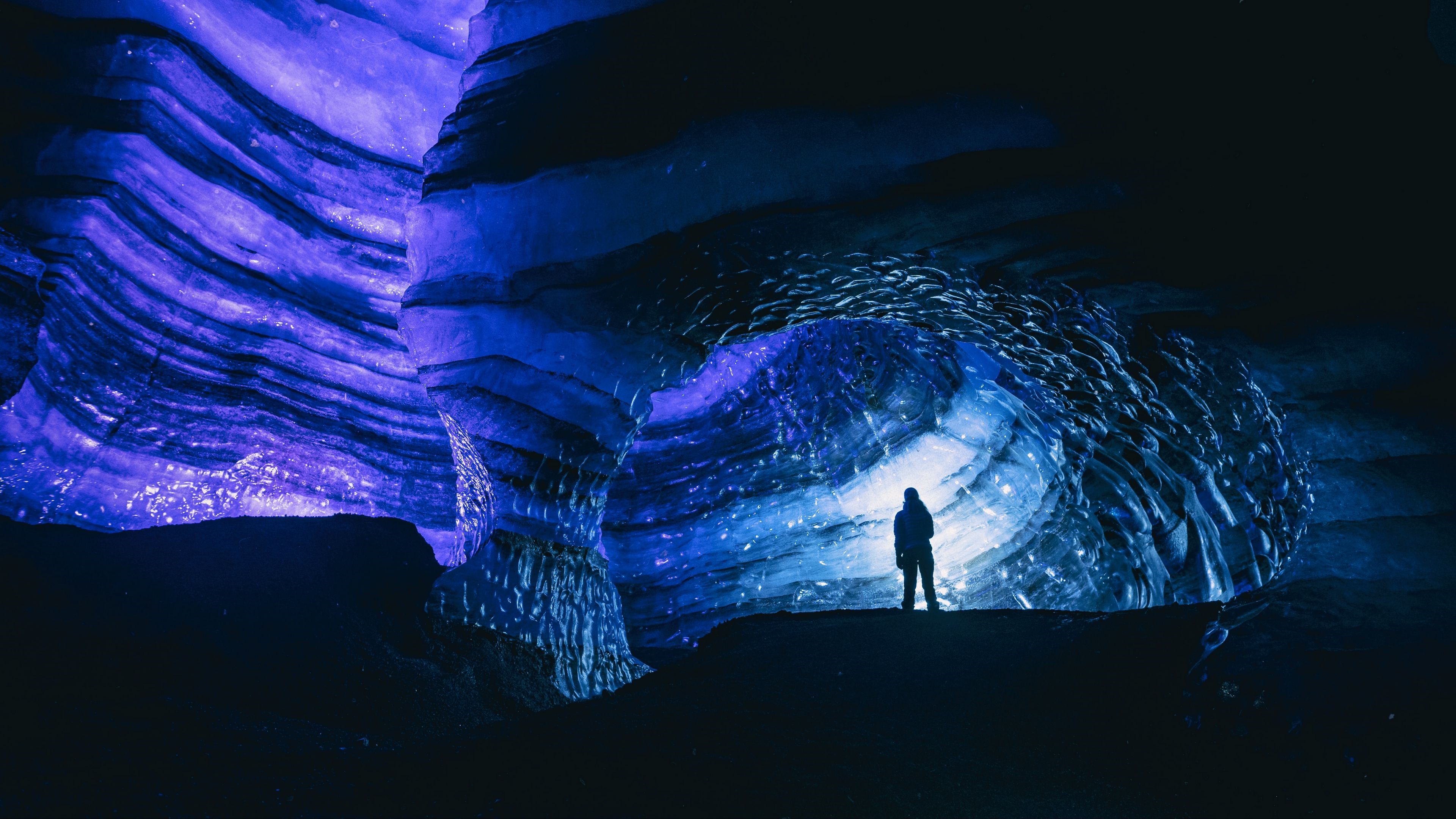 Silhouette in a glowing blue ice cave HD Wallpaper