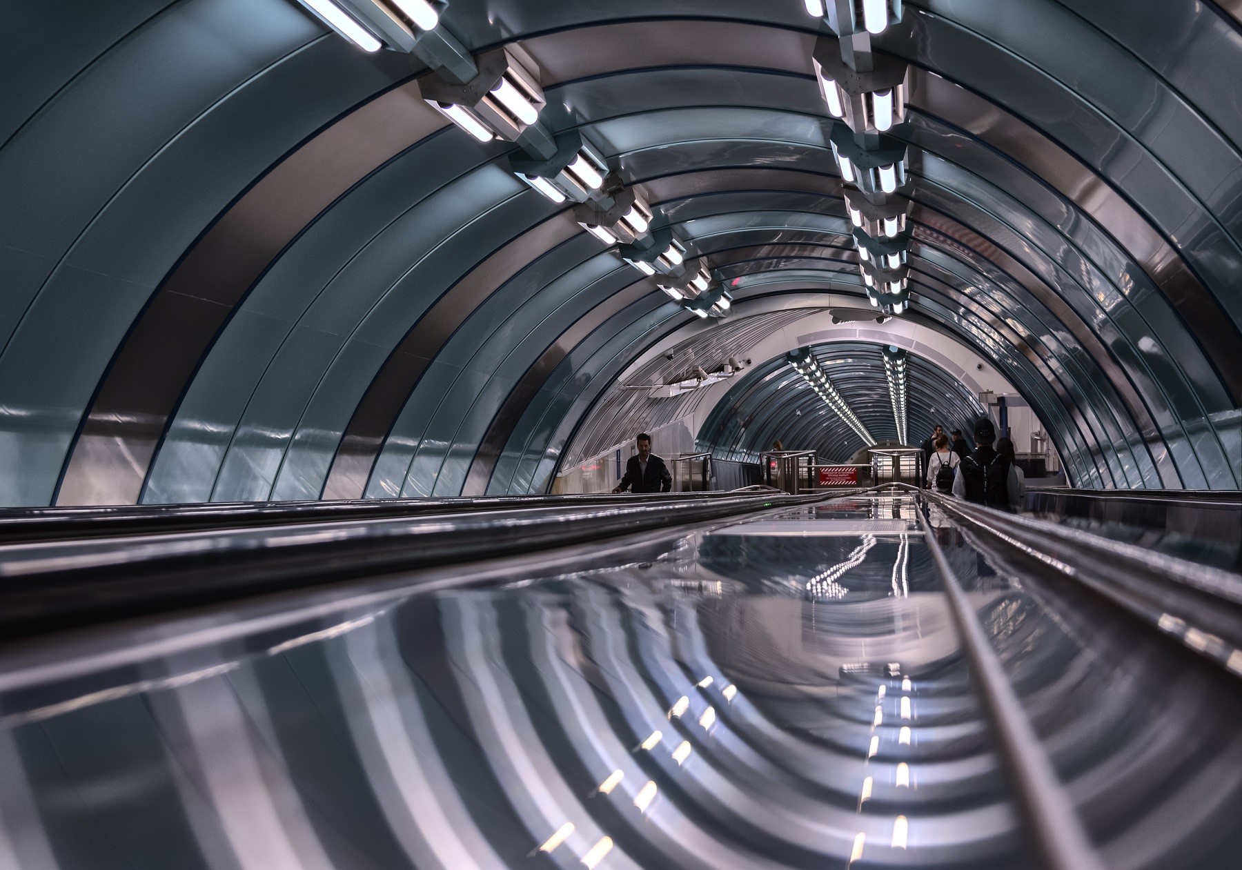 Modern subway escalator with people and reflections HD Wallpaper