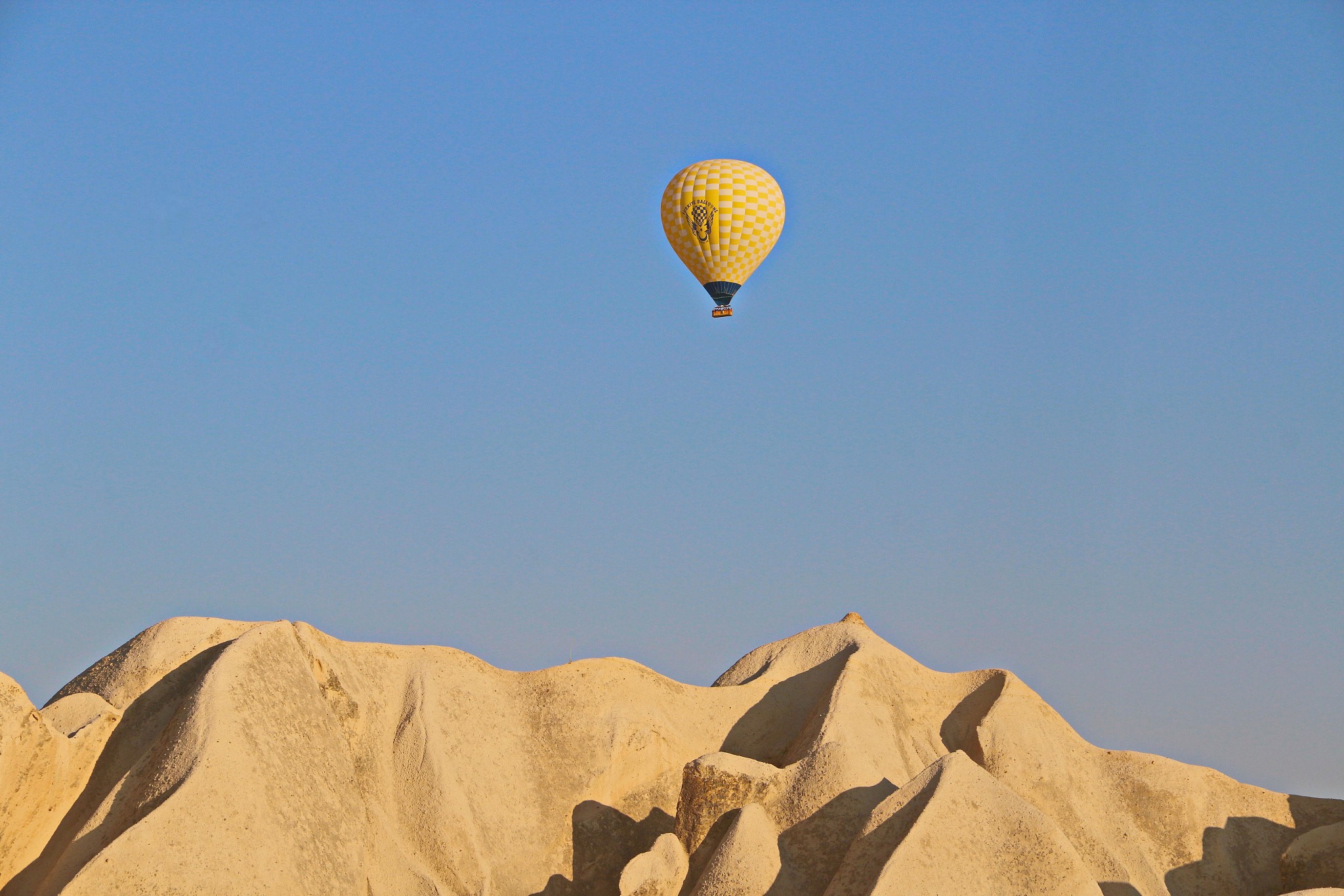 Yellow hot air balloon over desert landscape HD Wallpaper
