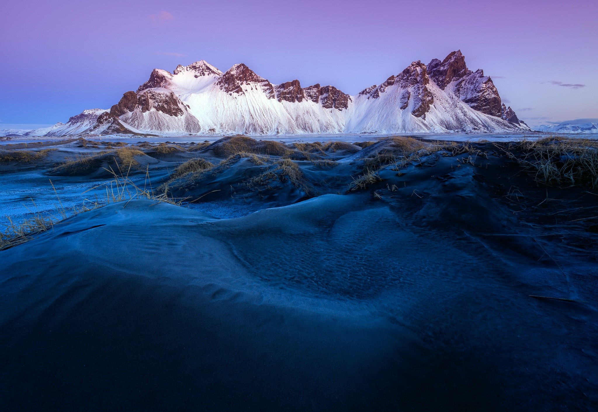 Snowy mountains in Iceland with dark sand dunes HD Wallpaper