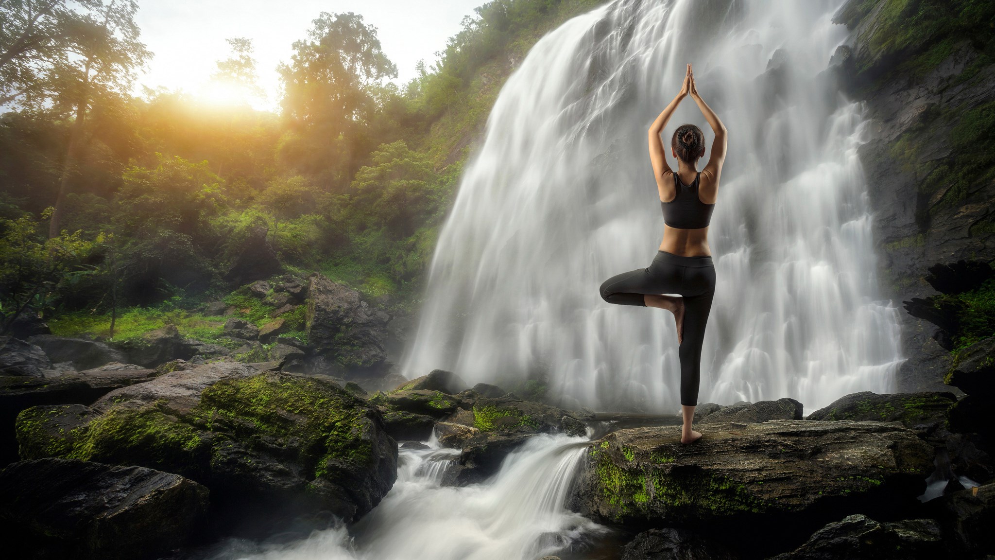 Woman doing yoga in front of a waterfall HD Wallpaper
