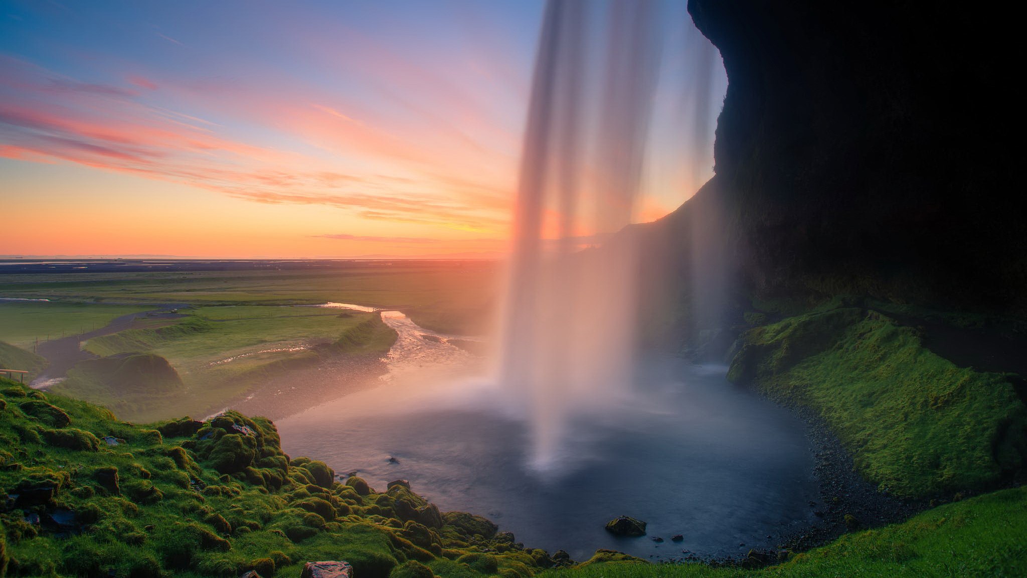 Waterfall at sunset with a river and green fields HD Wallpaper