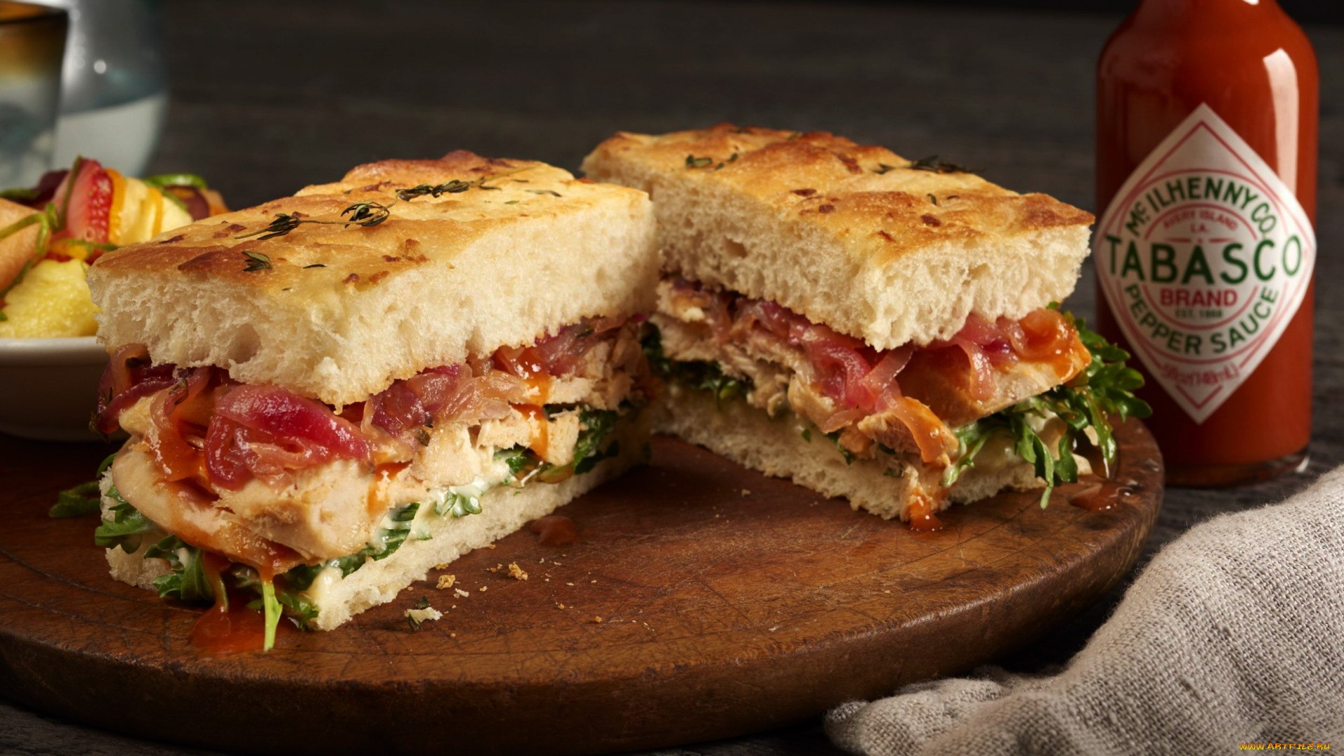 Chicken sandwich with Tabasco sauce on cutting board HD Wallpaper