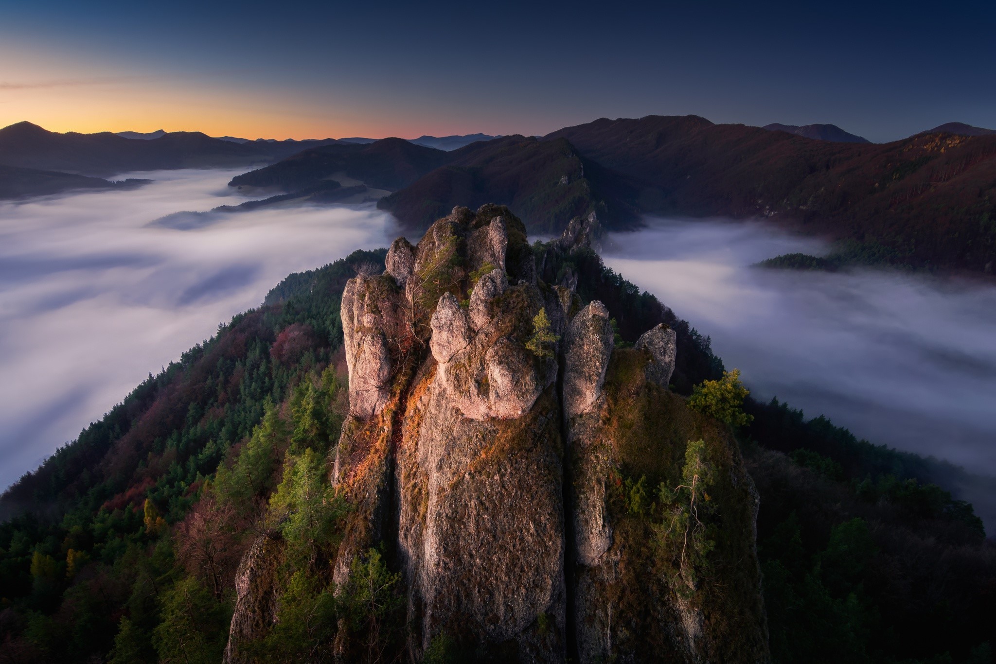 Rocky mountain peaks at sunrise with fog HD Wallpaper