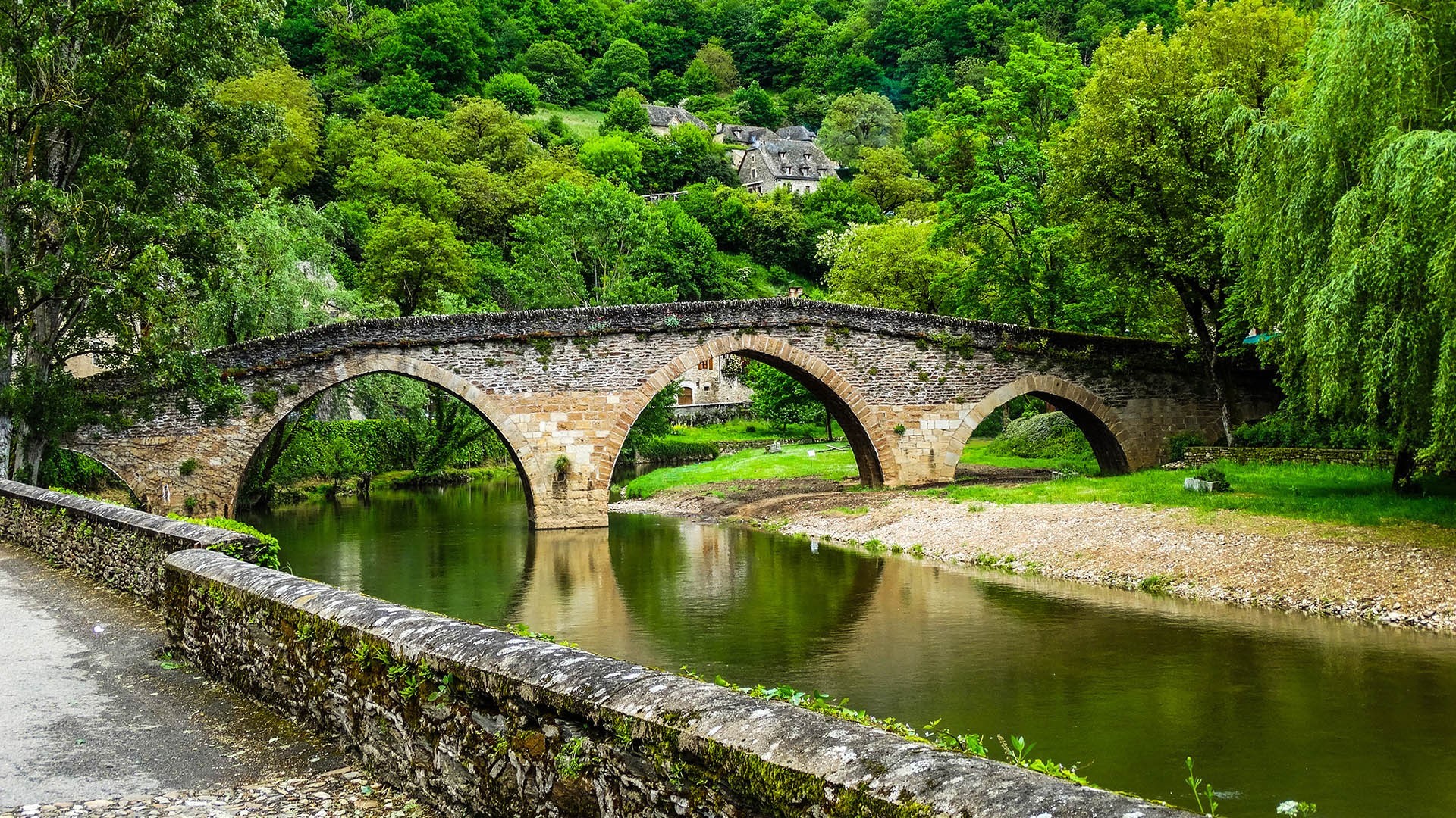 Stone bridge over a river in a green landscape HD Wallpaper