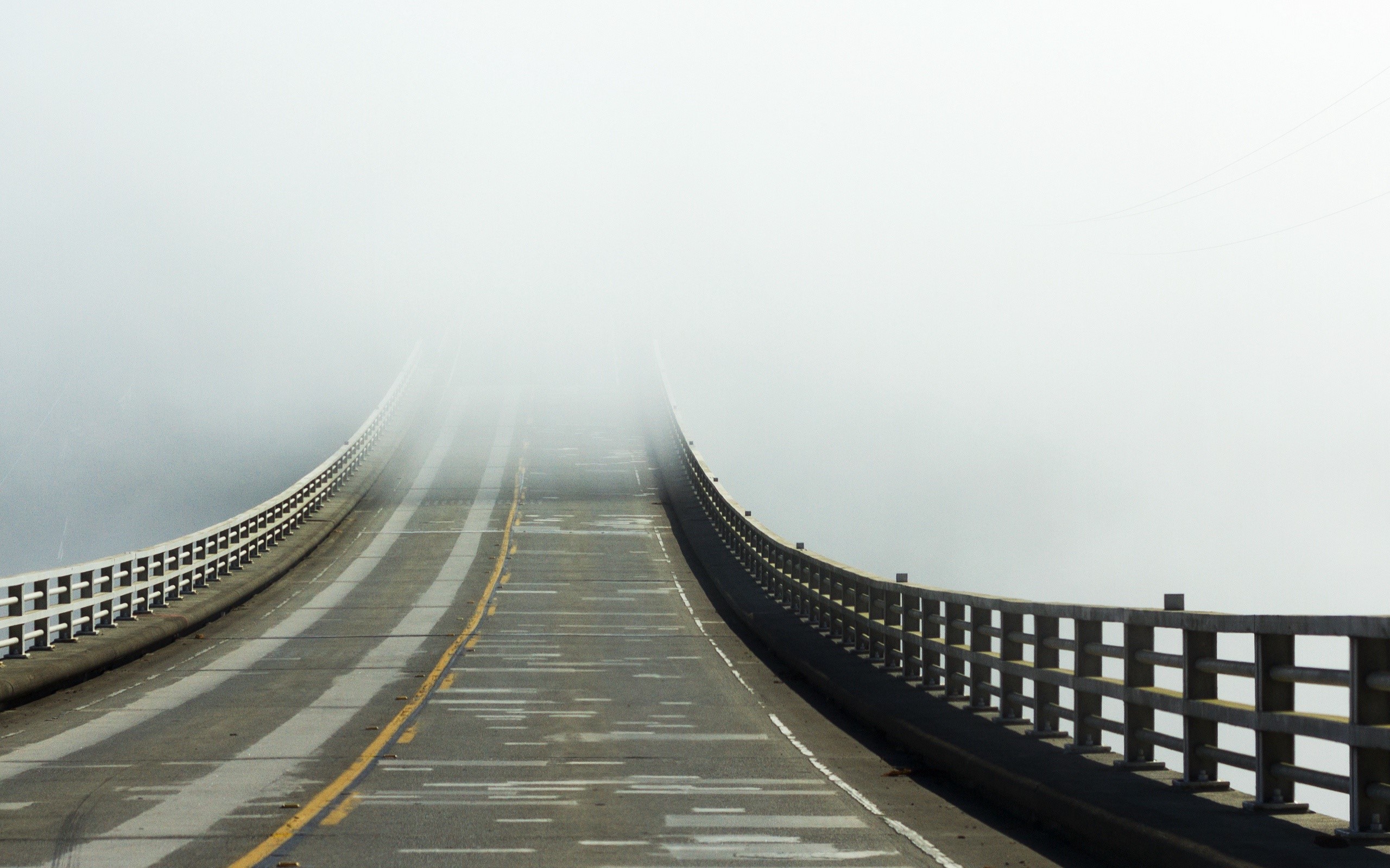 Road on a bridge disappearing into fog HD Wallpaper