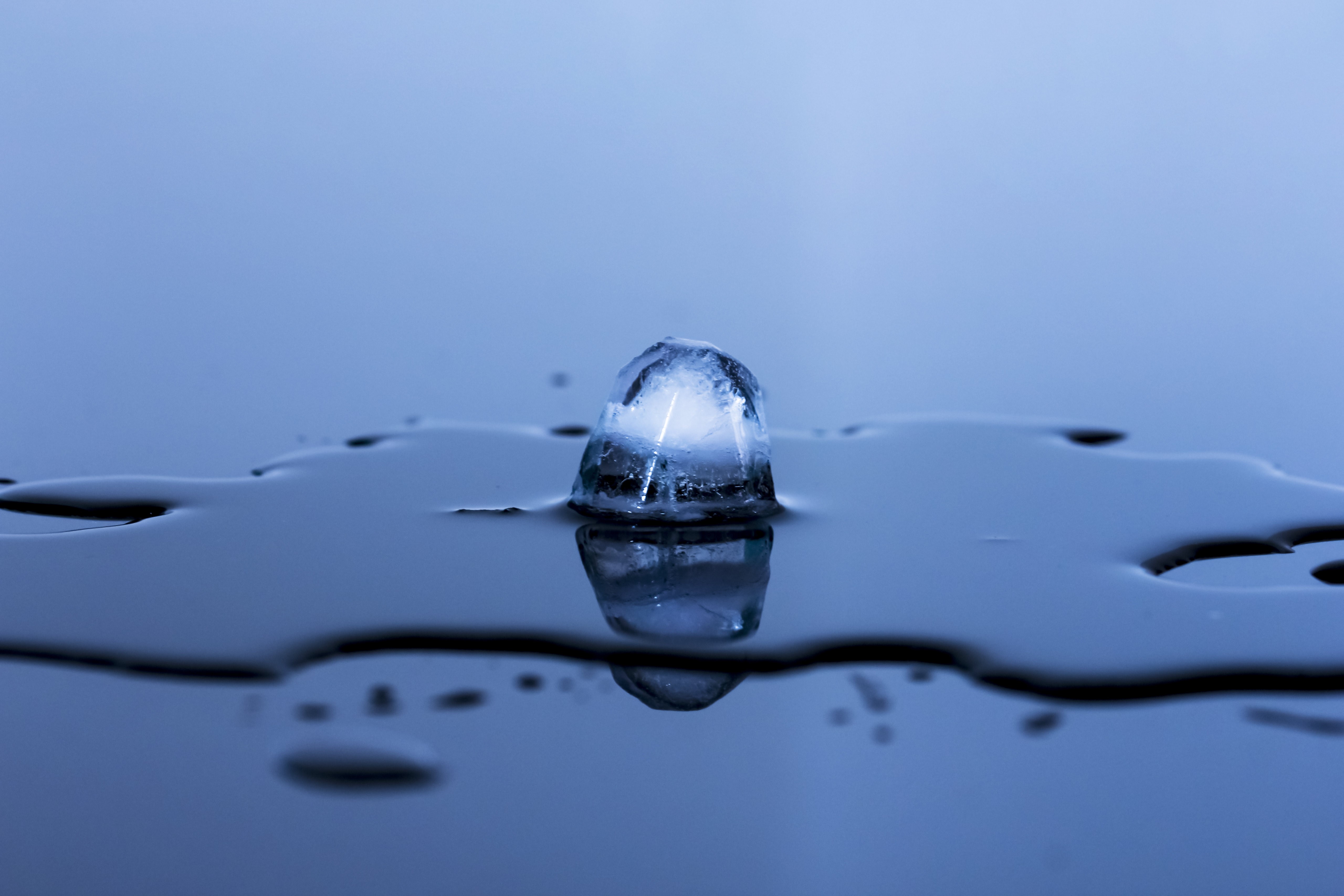 Melting ice cube with reflection HD Wallpaper