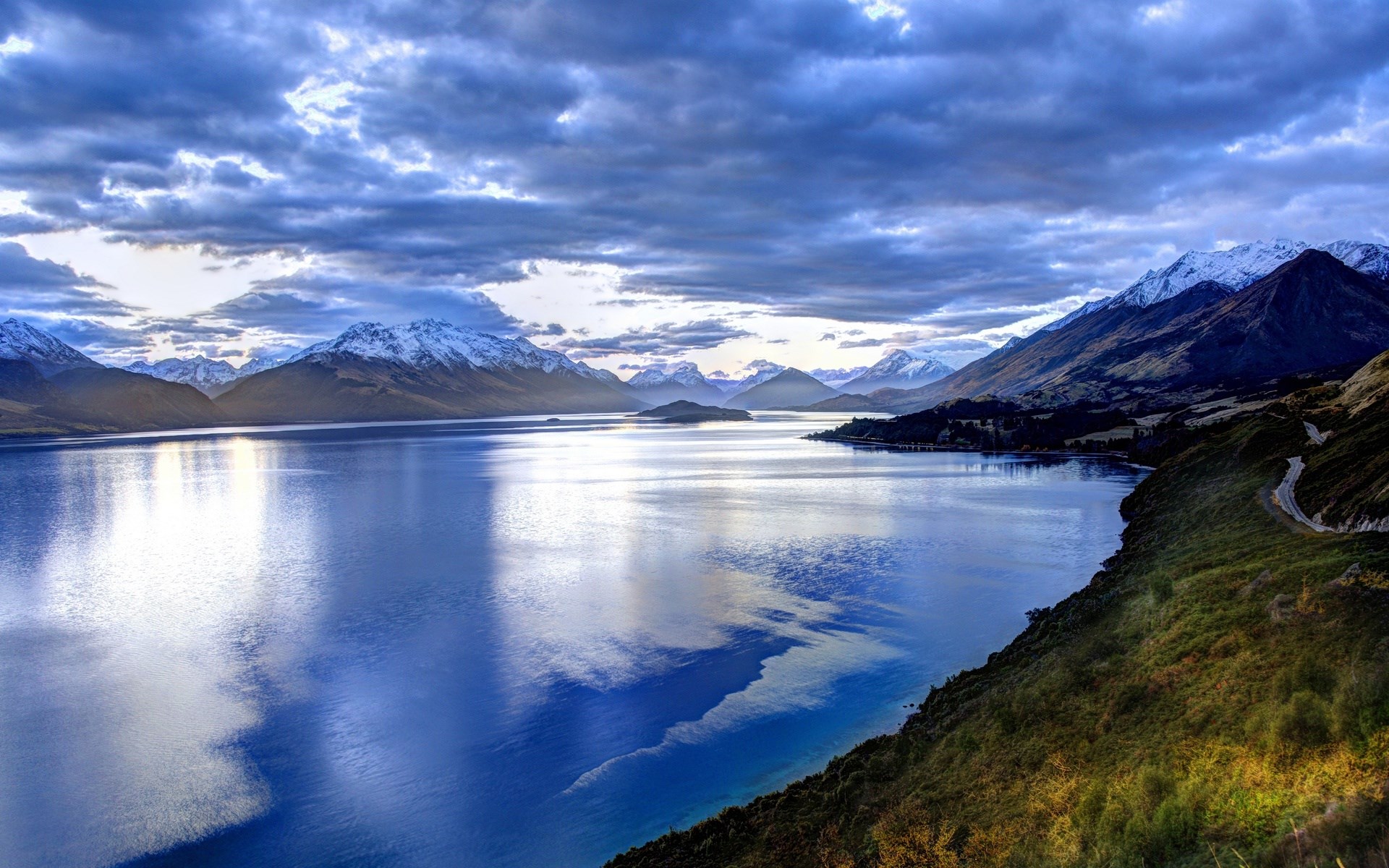 Lake Wakatipu with snow-capped mountains and cloudy sky HD Wallpaper