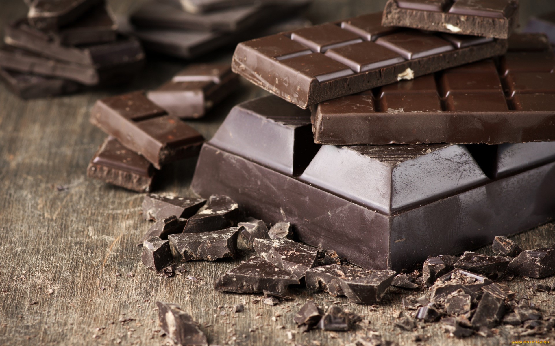 Dark chocolate bars and pieces on wooden surface HD Wallpaper