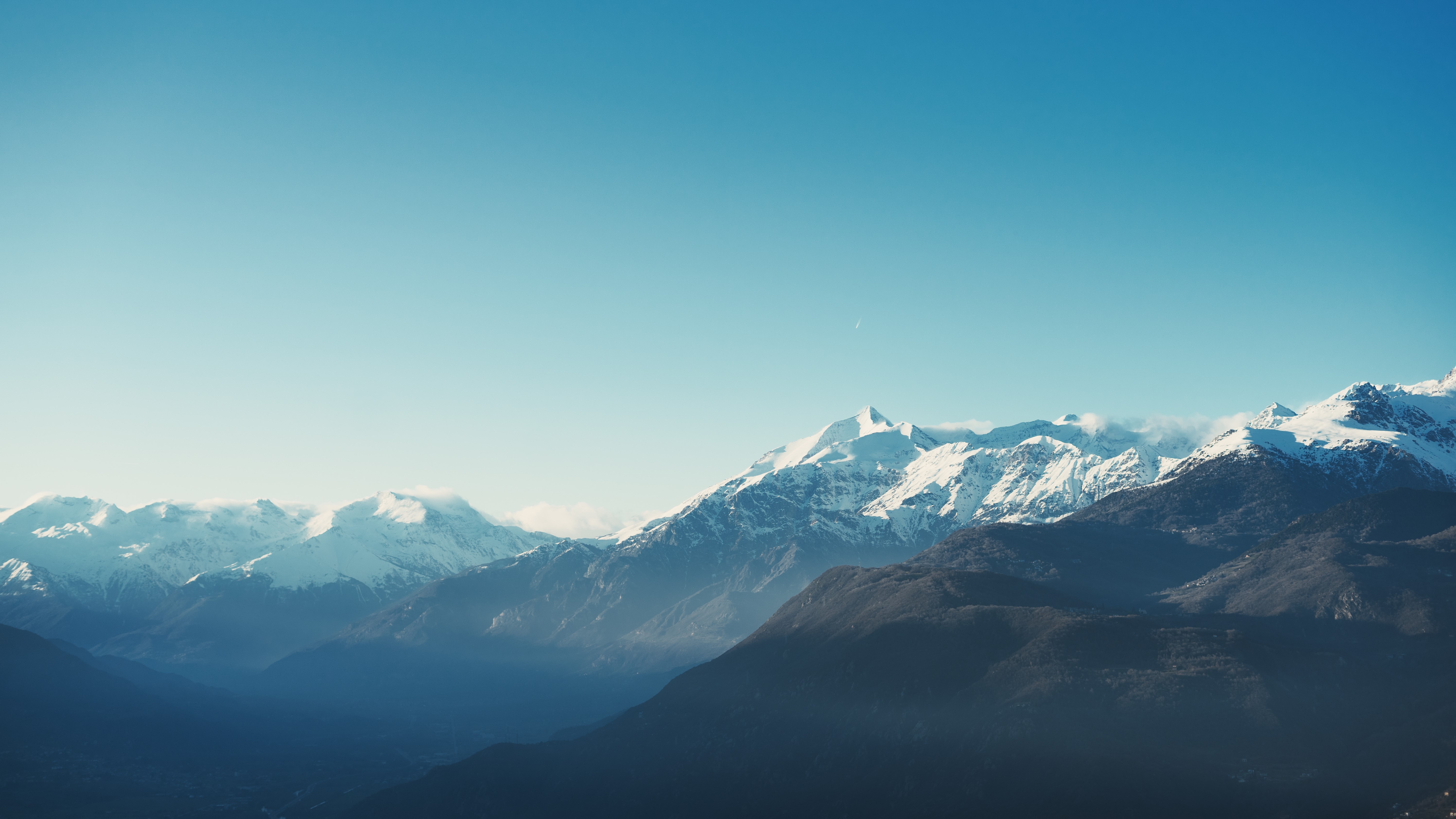 Snowy mountain peaks under a clear blue sky HD Wallpaper