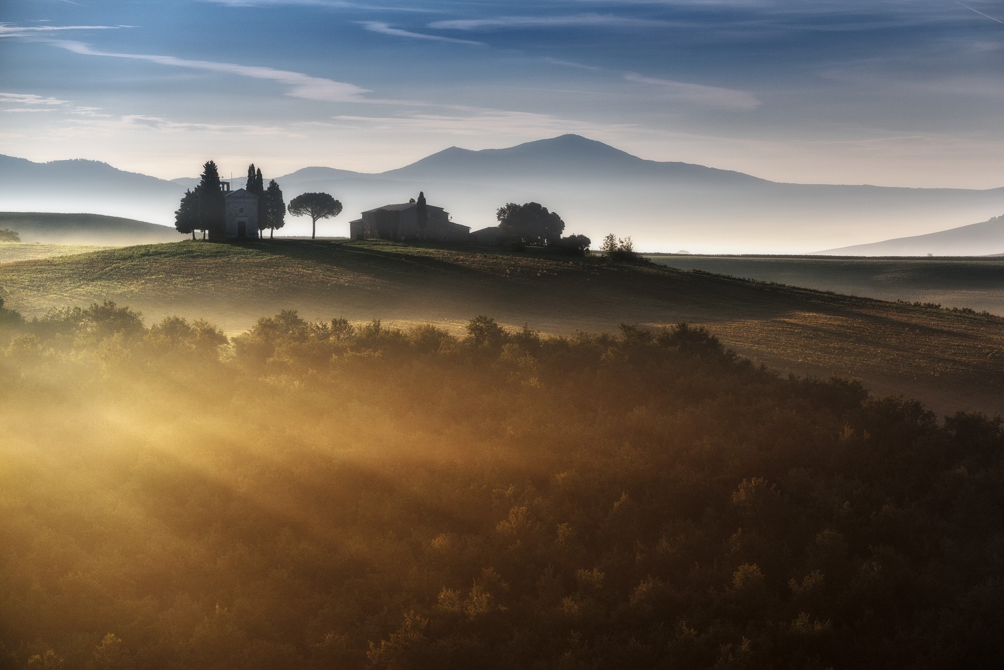 Tuscan landscape with sun rays and mist HD Wallpaper
