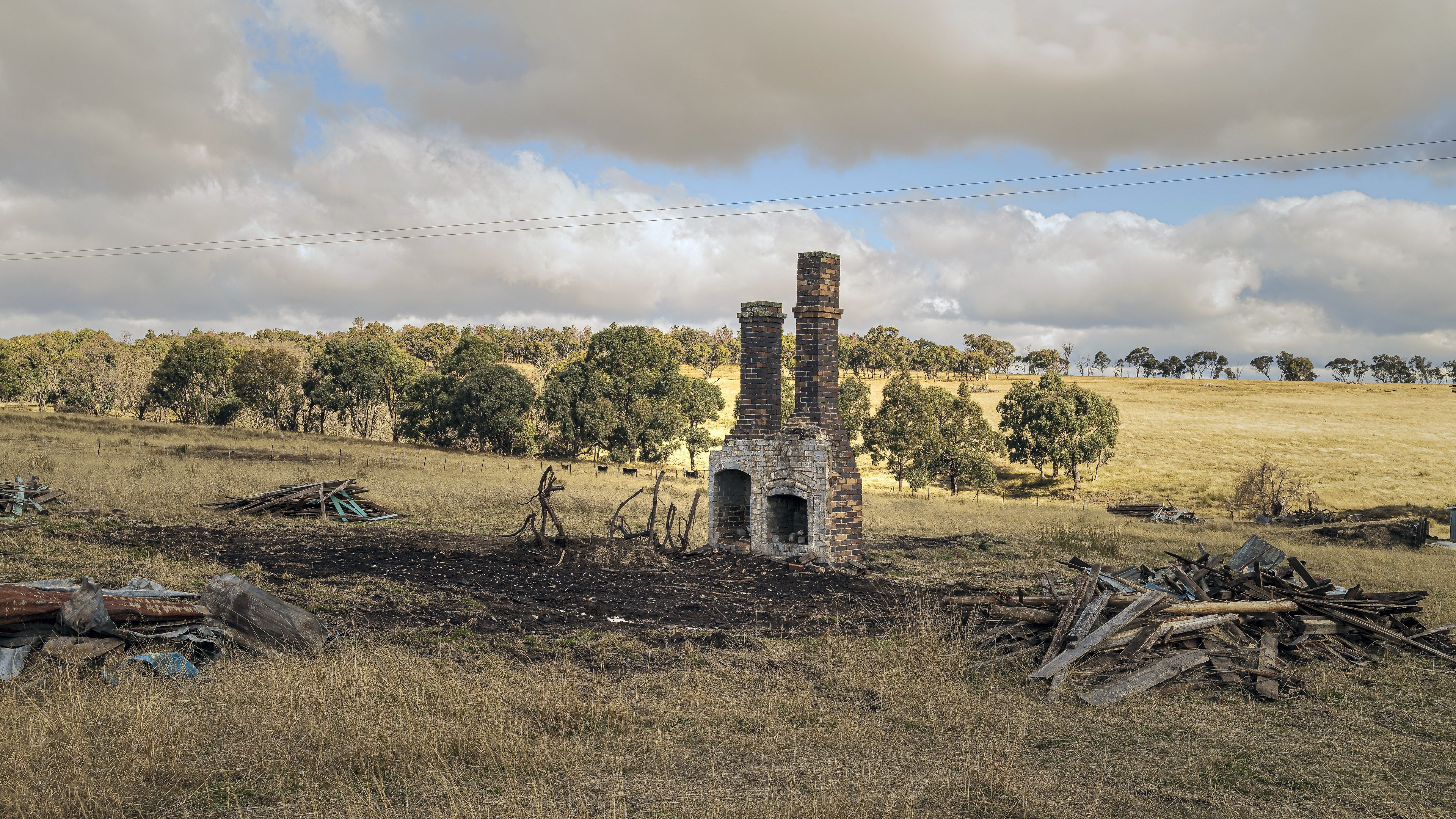 Ruined chimneys in a dry grassy field HD Wallpaper