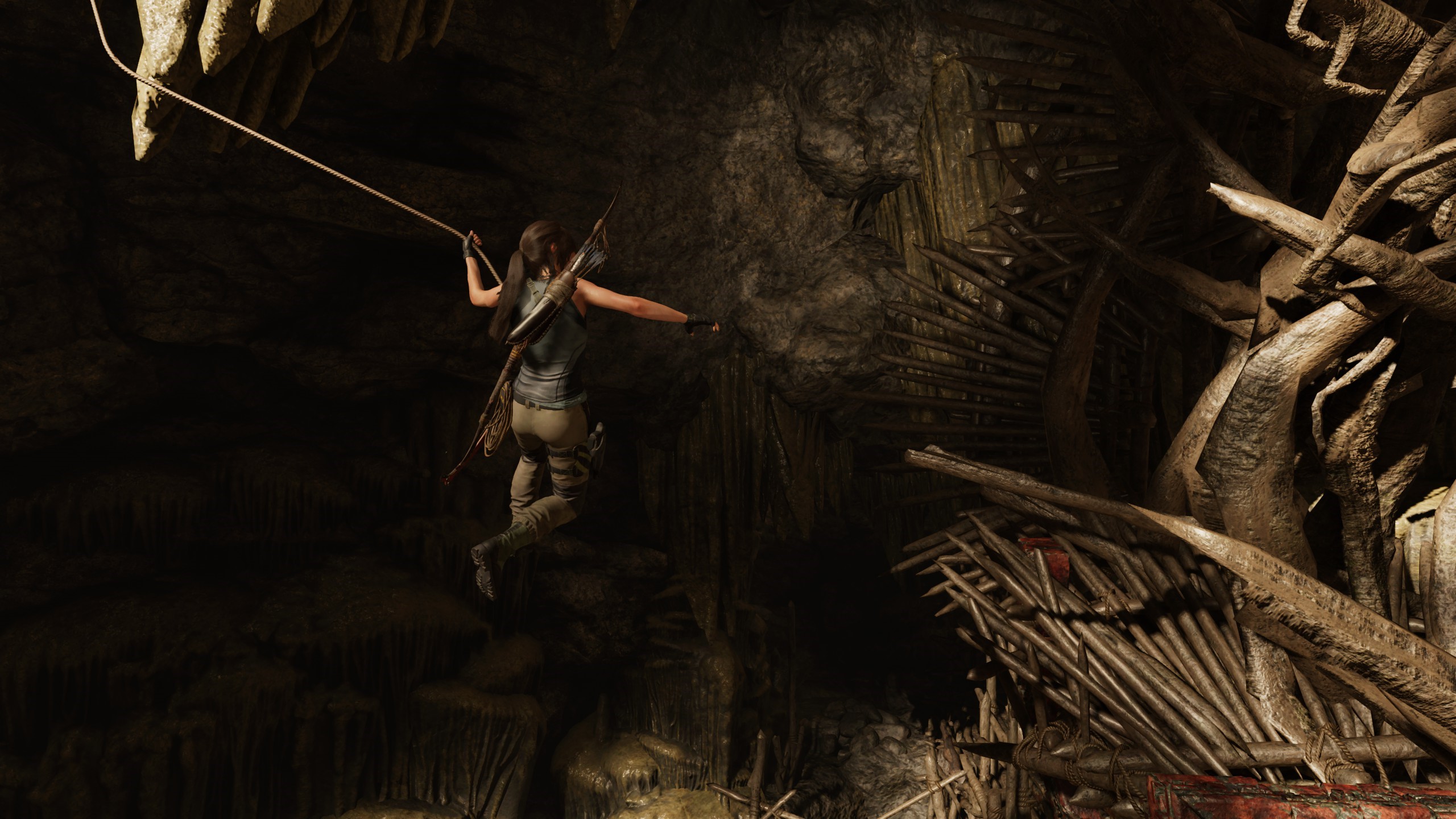 Lara Croft from Tomb Raider swinging on a rope in a cave HD Wallpaper