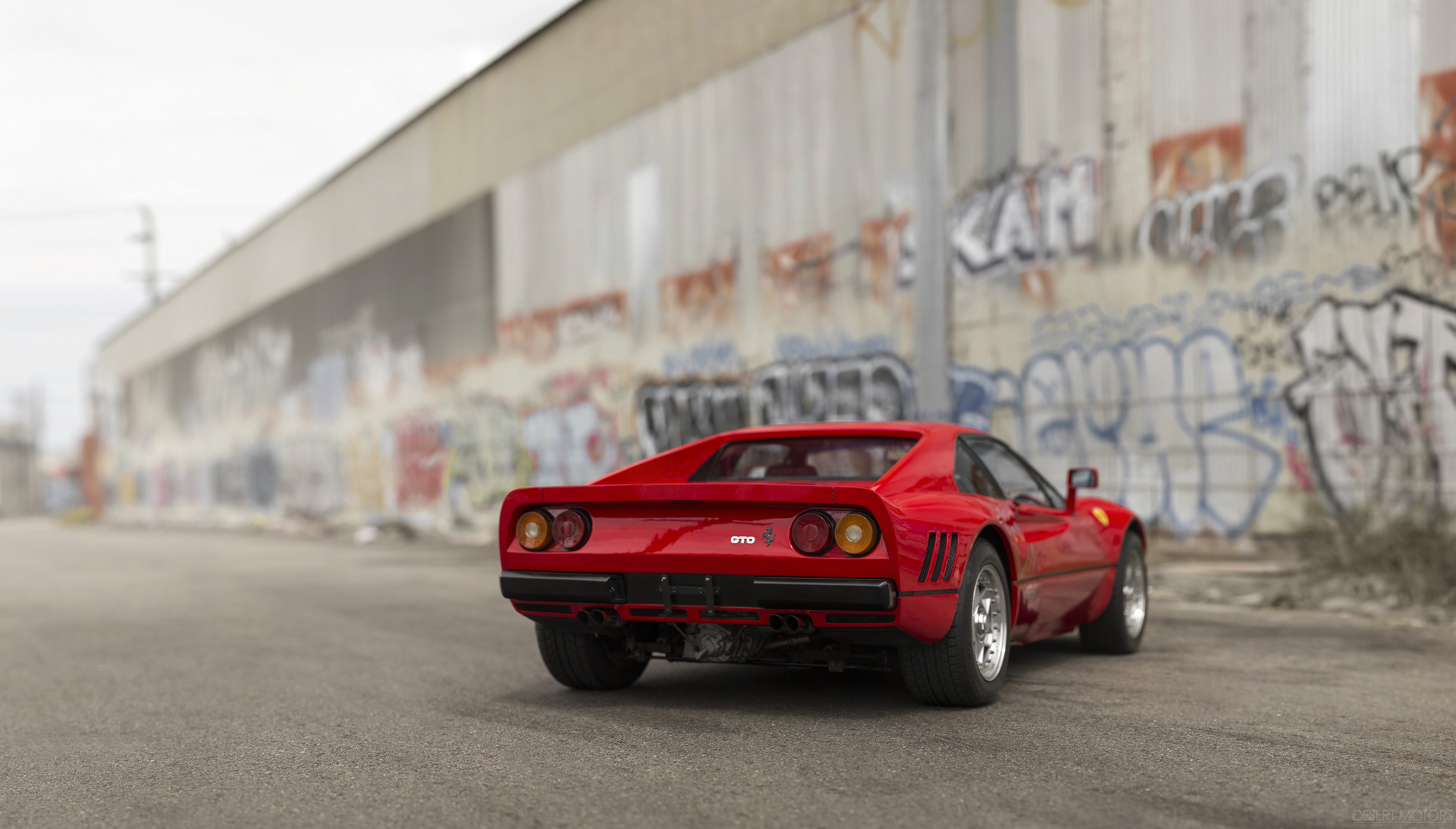 Red Ferrari 288 GTO sports car parked near graffiti wall HD Wallpaper