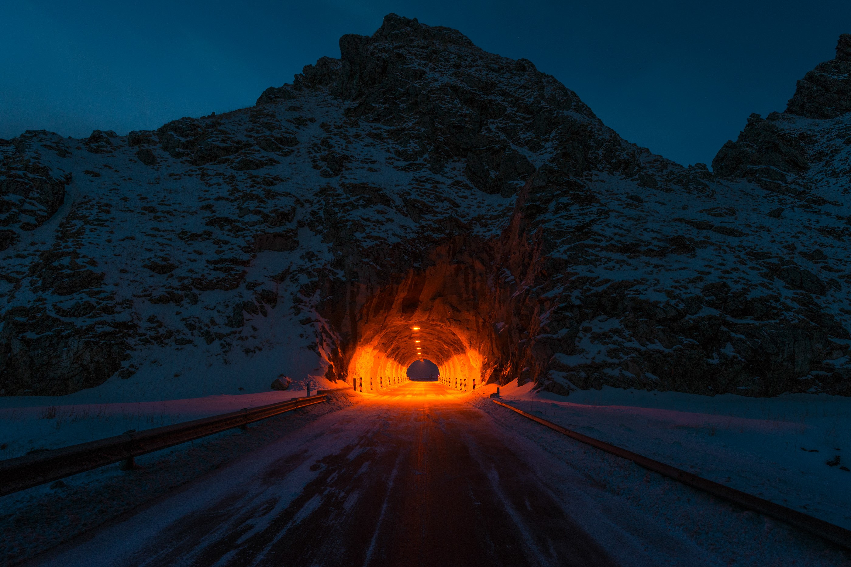 Snowy mountain tunnel entrance at night HD Wallpaper