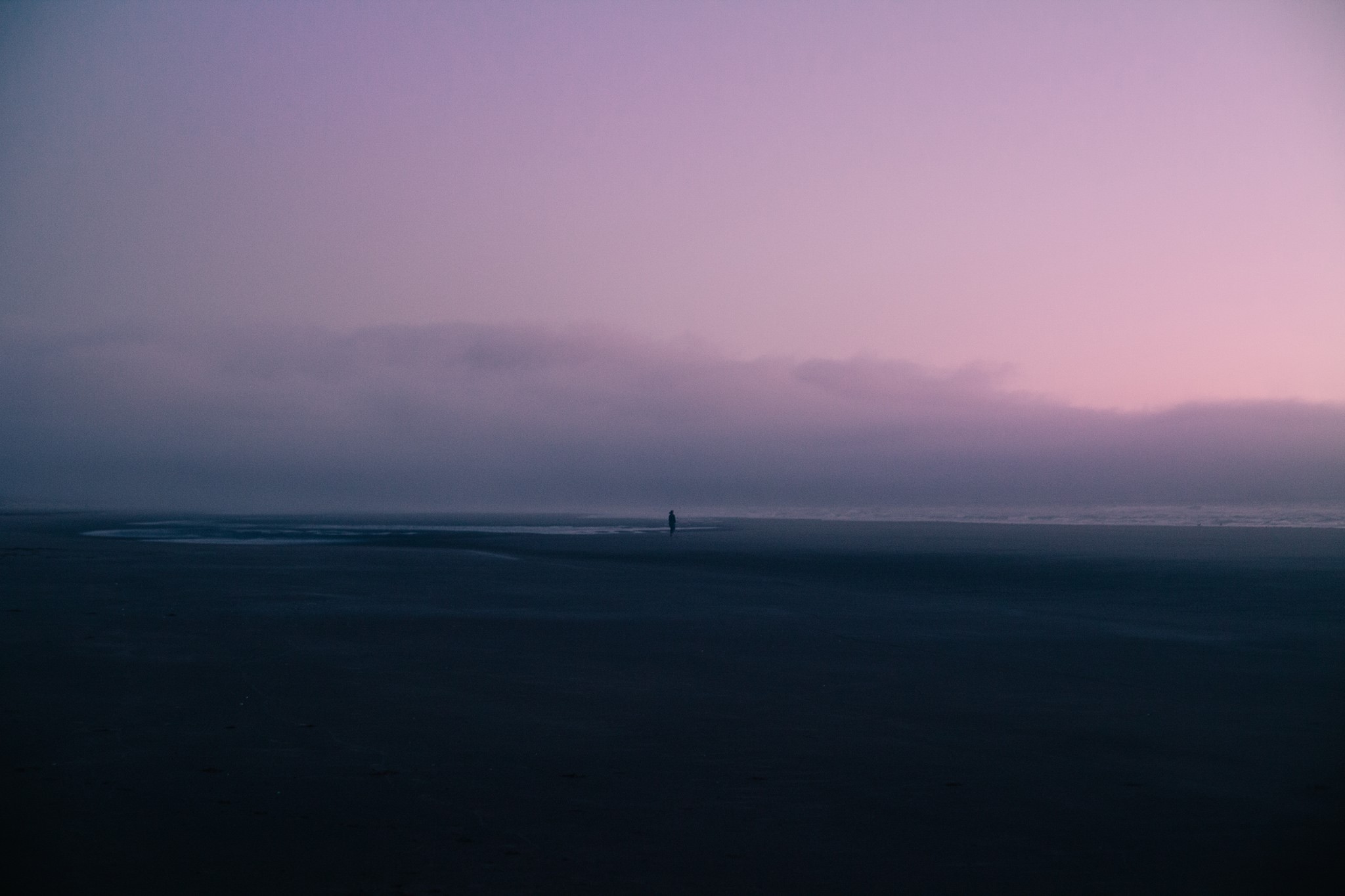 Person walking on a foggy beach at sunset HD Wallpaper