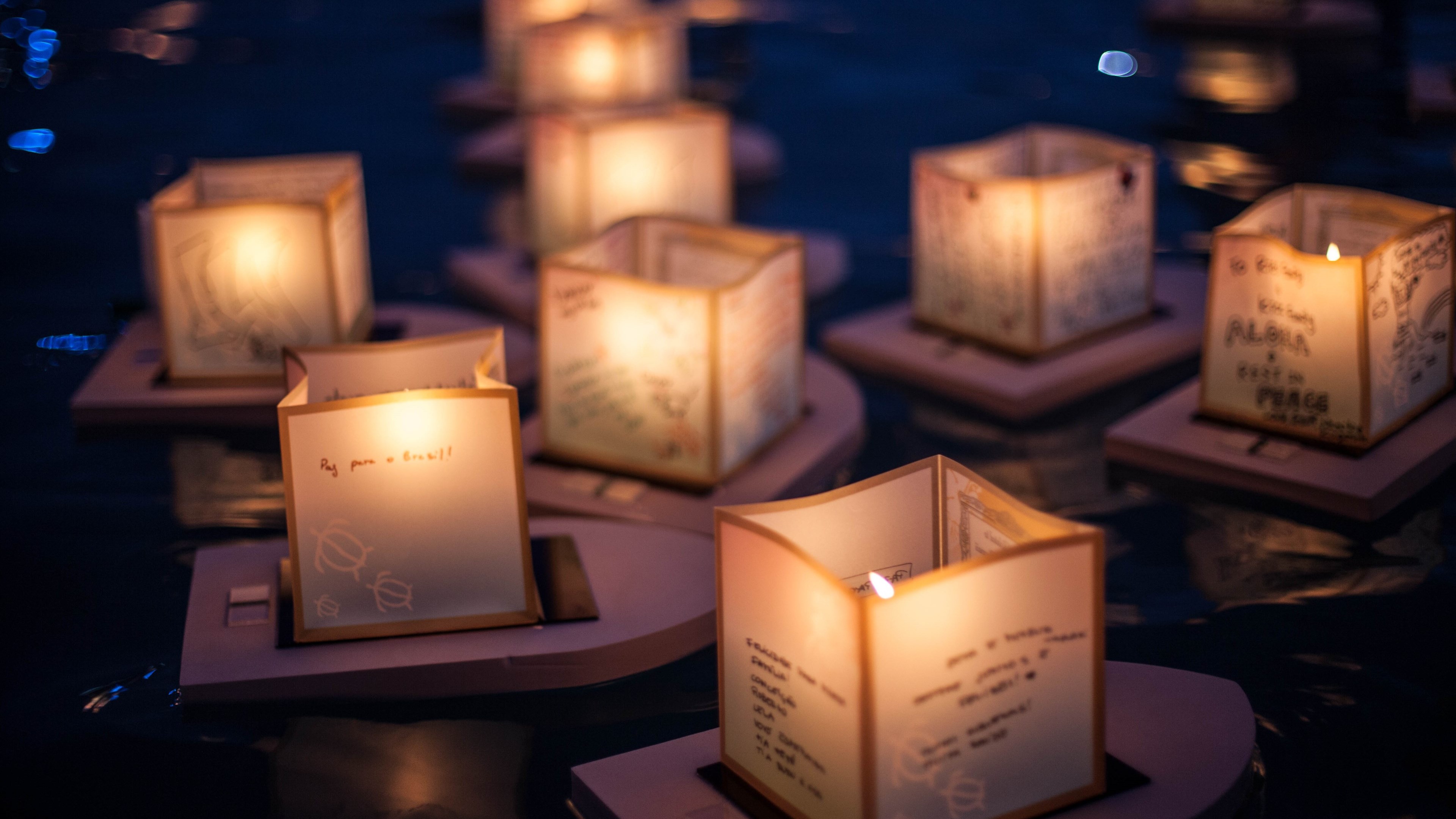 Floating lanterns with candles at night HD Wallpaper
