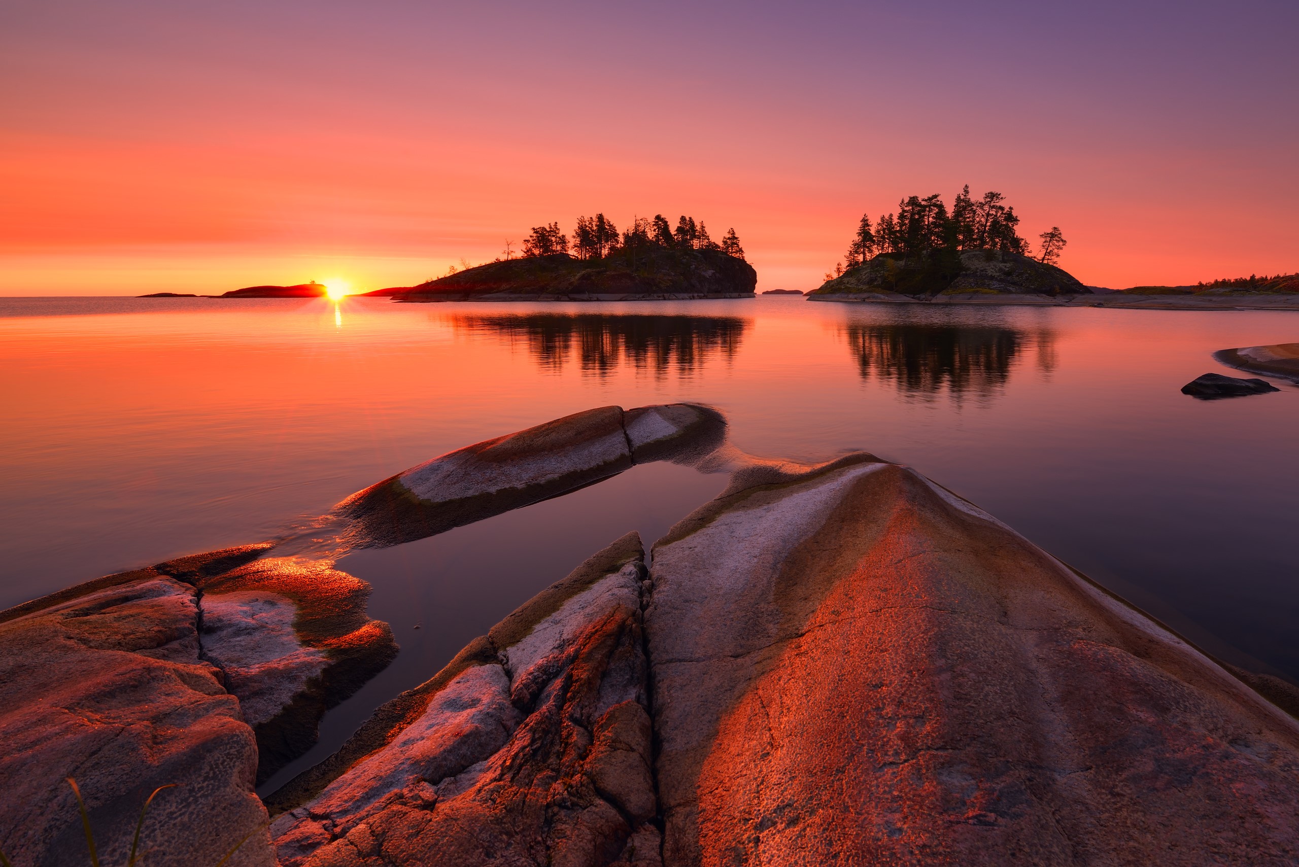 Sunrise over a lake with islands and rocks HD Wallpaper