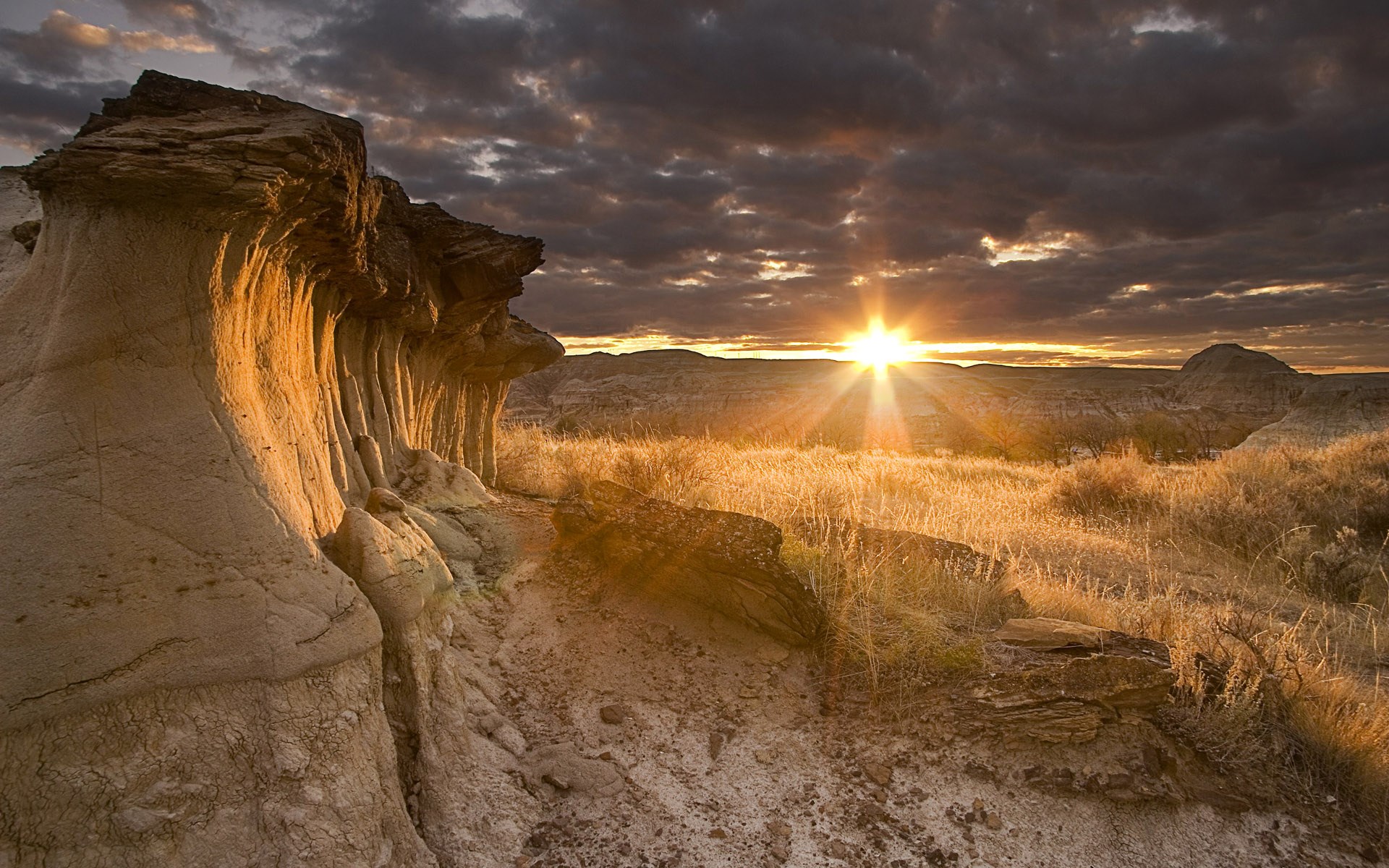 Sunset over a rocky desert landscape with hoodoos HD Wallpaper