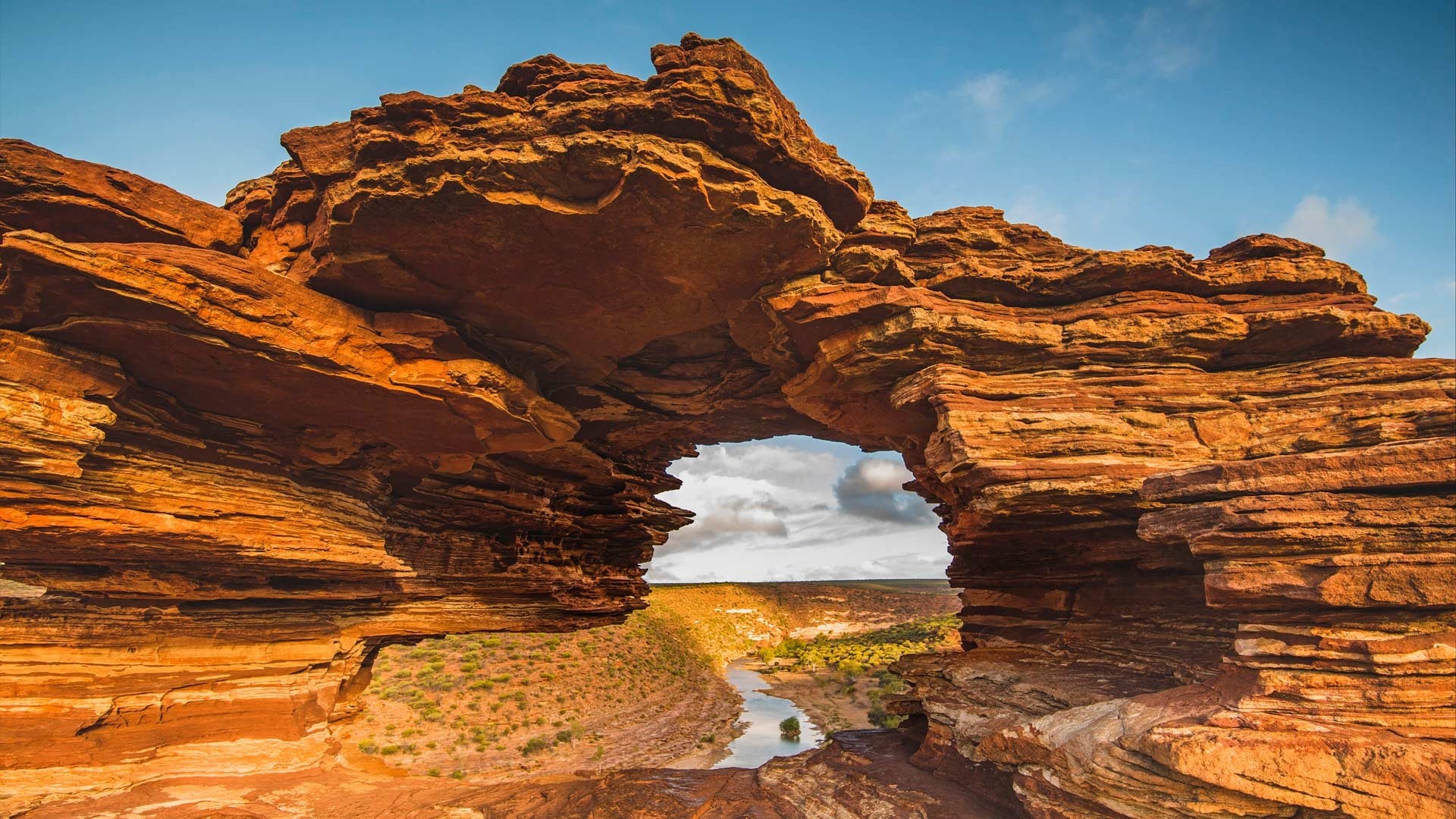 Natural rock arch over a river canyon HD Wallpaper
