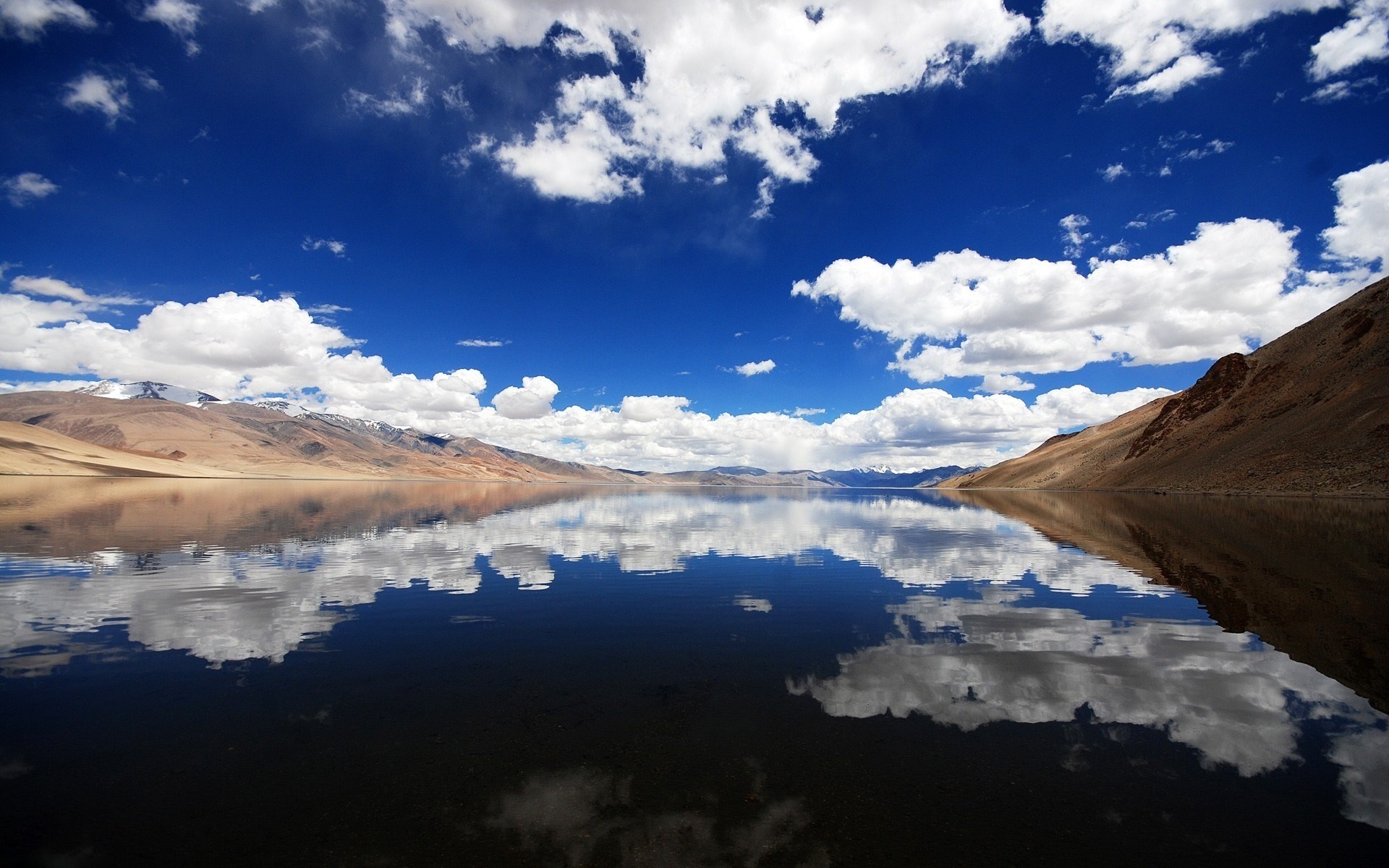 Lake reflecting mountains and clouds under a blue sky HD Wallpaper